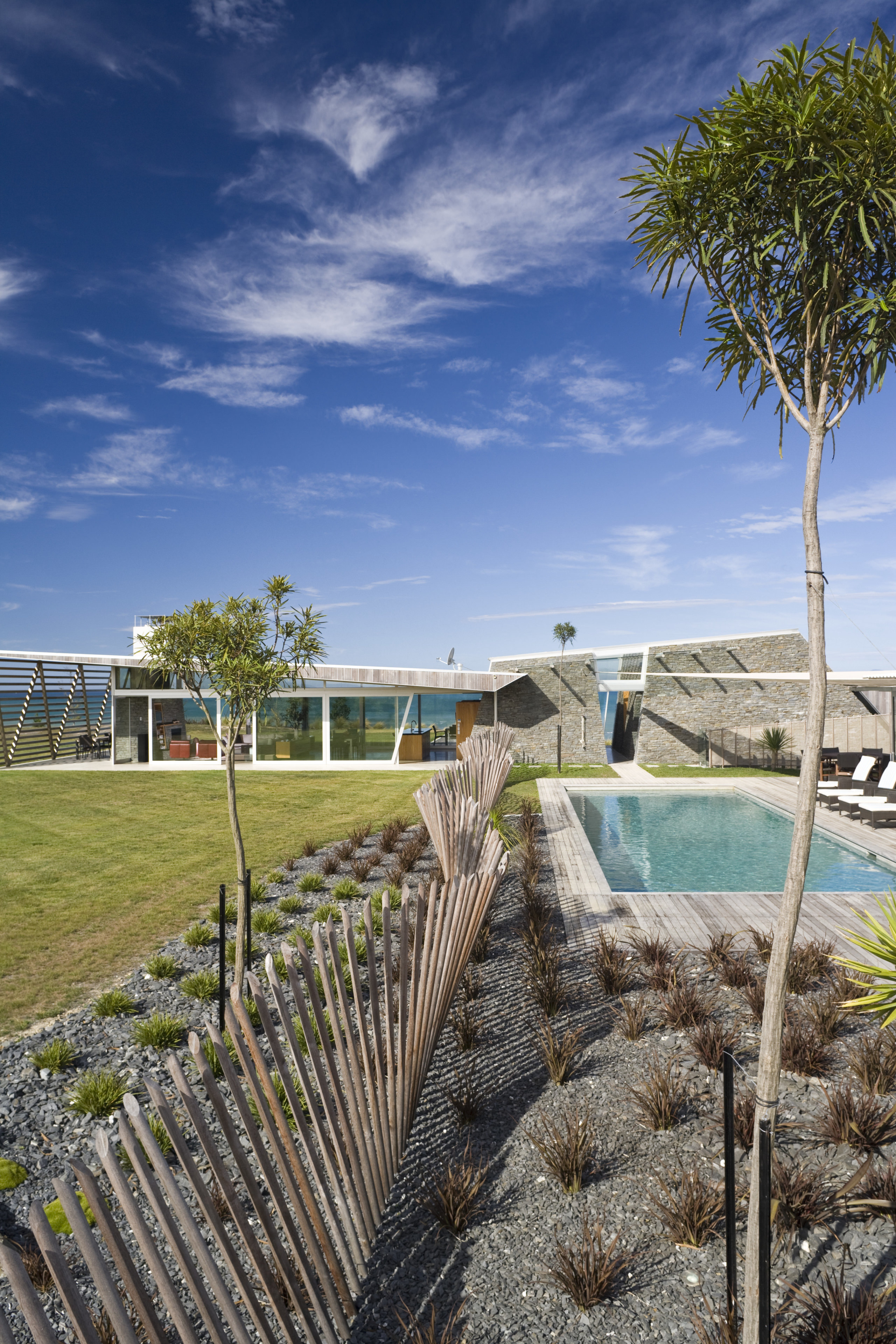 Exterior view of the outdoor area with pool, arecales, cloud, coast, estate, home, house, landscape, ocean, palm tree, plant, property, real estate, sea, shore, sky, tree, tropics, vacation, walkway, water