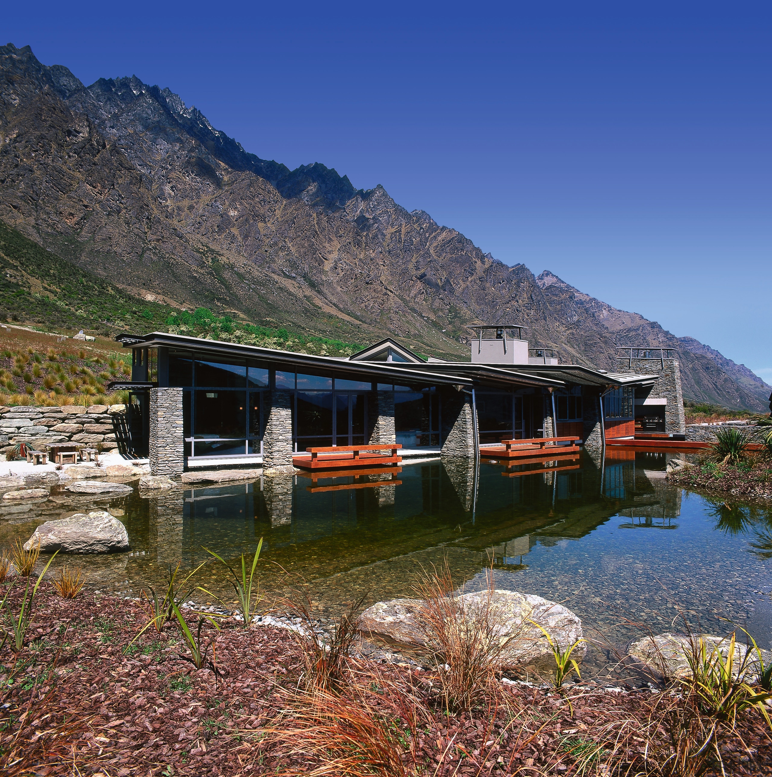 view of theis new house tucked beneath the alps, cottage, fjord, house, hut, lake, landscape, loch, mountain, mountain range, mountainous landforms, nature, plant, real estate, reflection, reservoir, rural area, sky, tree, water, wilderness, blue