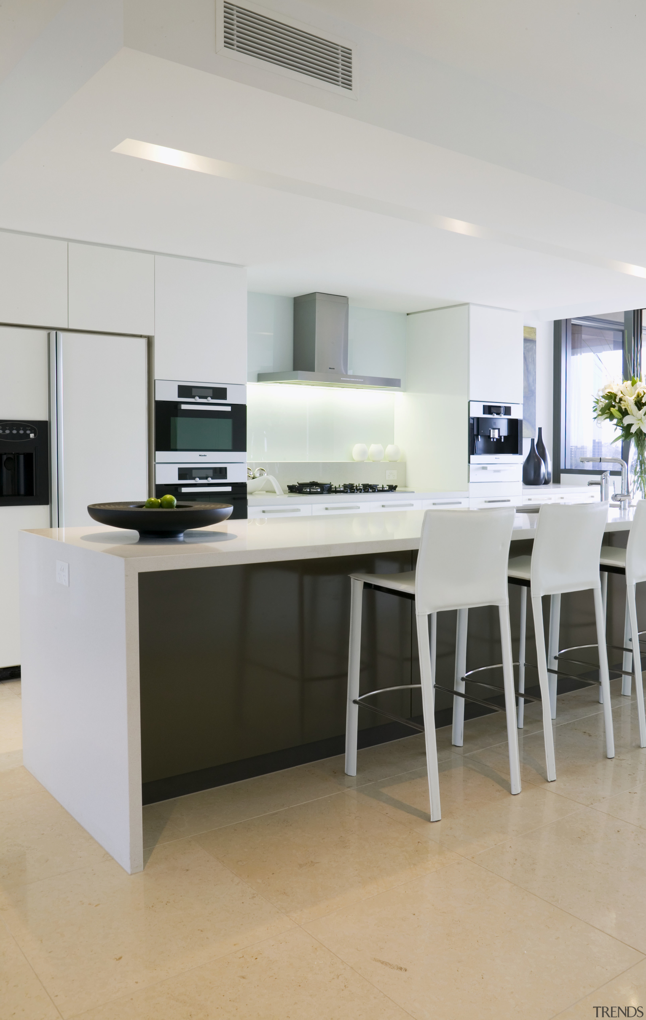 A view of the kitchen area featuring limestone countertop, floor, furniture, interior design, kitchen, product design, table, gray