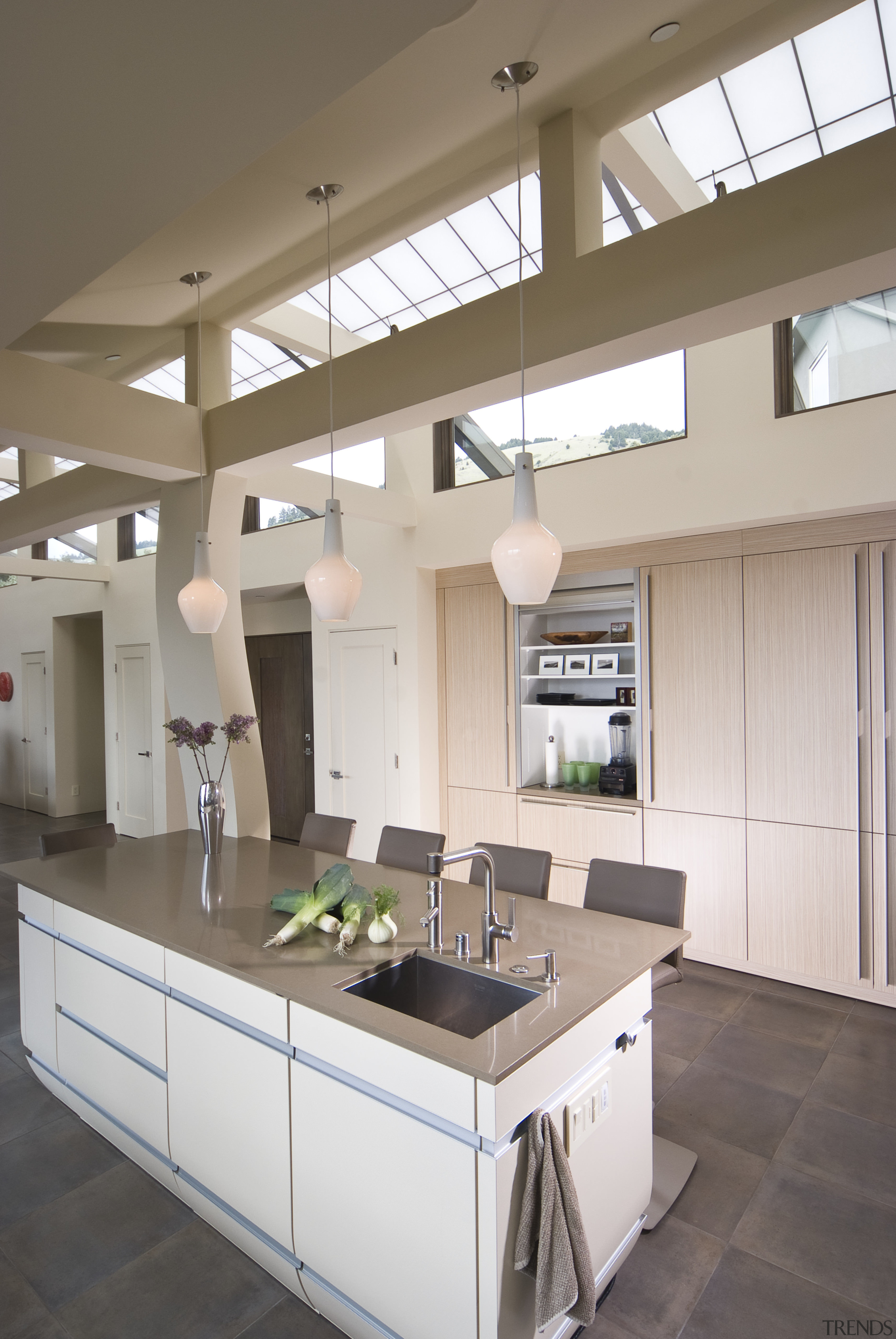 View of neutral-toned kitchen and dining space, featuring cabinetry, ceiling, countertop, cuisine classique, daylighting, interior design, kitchen, gray, brown