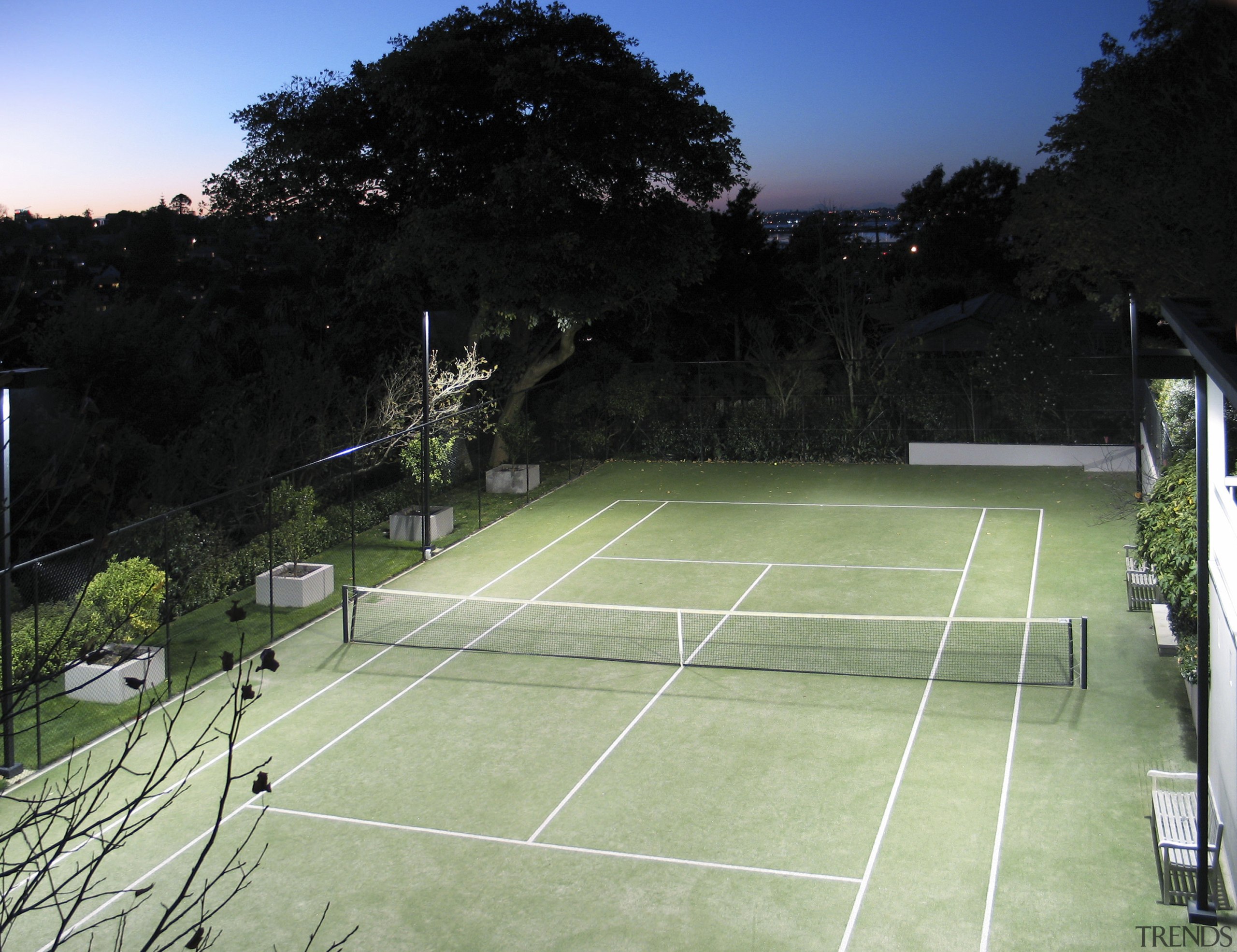 Image of a residential tennis court which was area, grass, net, plant, sky, sport venue, sports, structure, tennis, tennis court, green, black