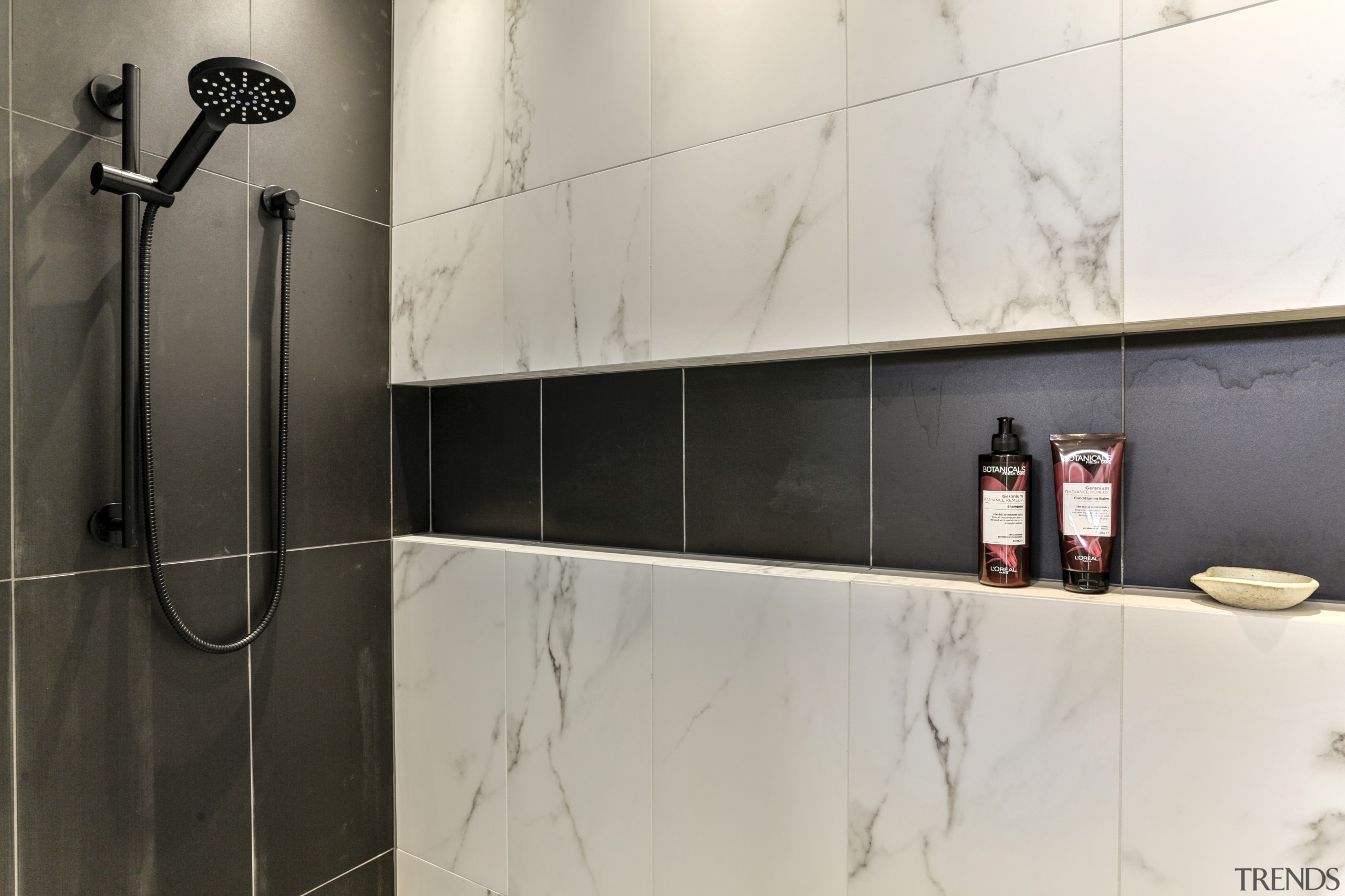 ​​​​​​​A long, walk-in shower stall allows for an gray, black