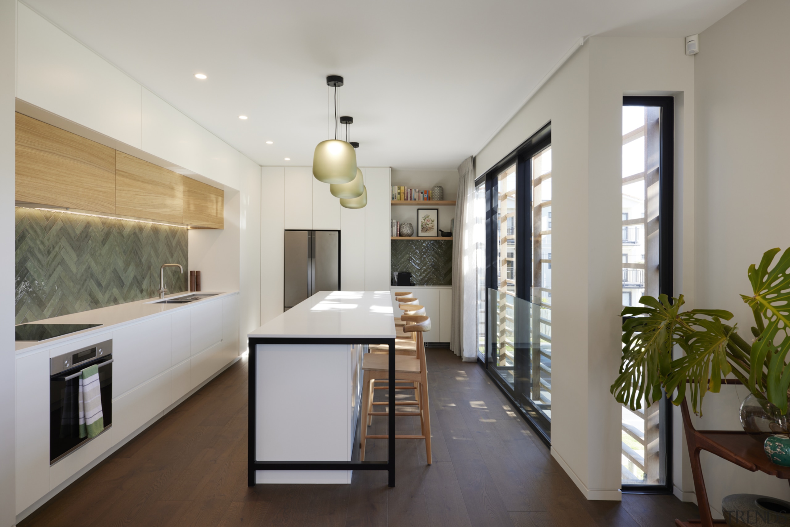 Sunlit kitchen with herringbone feature splashbacks and contemporary 