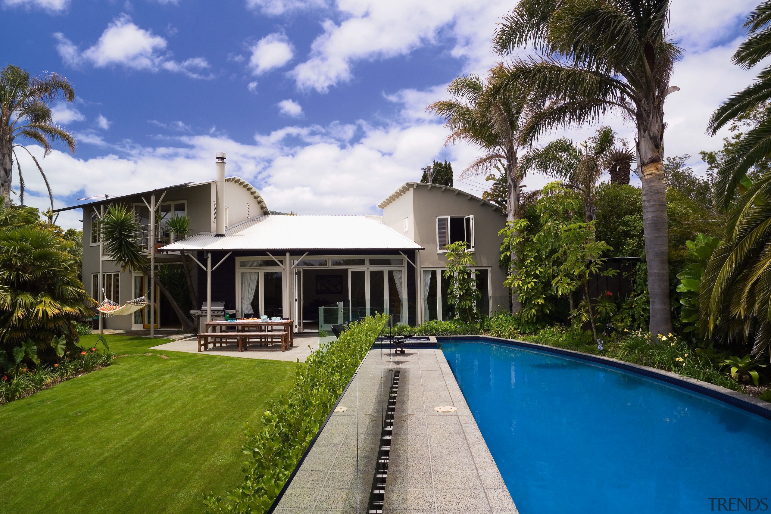 The orientation of the pool gives uninterrupted views arecales, cottage, estate, facade, hacienda, home, house, mansion, palm tree, property, real estate, resort, sky, swimming pool, tree, villa, brown