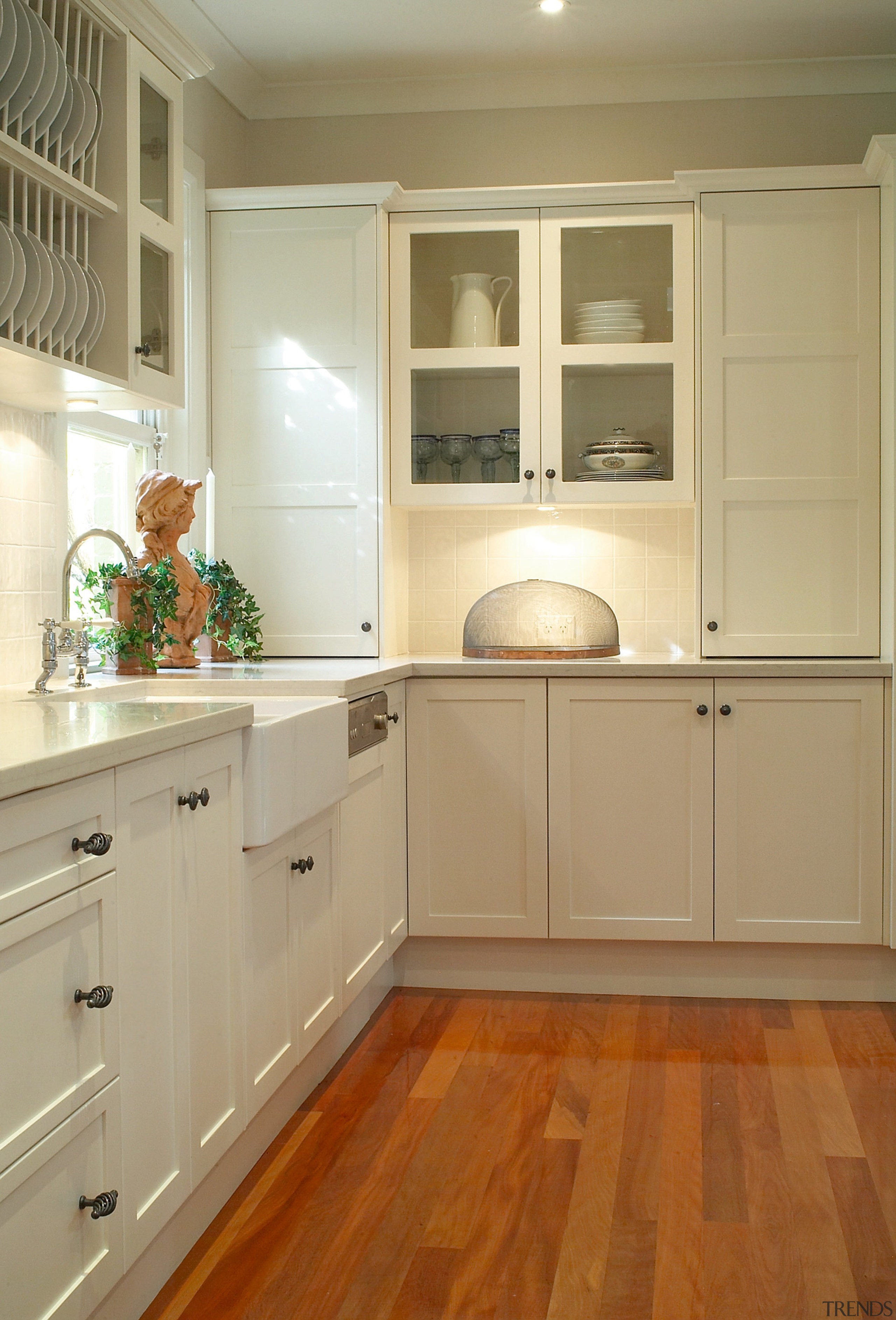 Kitchen with white cabinetry, metal handles, sunken sink, cabinetry, countertop, cuisine classique, floor, flooring, hardwood, home, home appliance, interior design, kitchen, laminate flooring, room, tile, wall, wood, wood flooring, wood stain, brown, orange