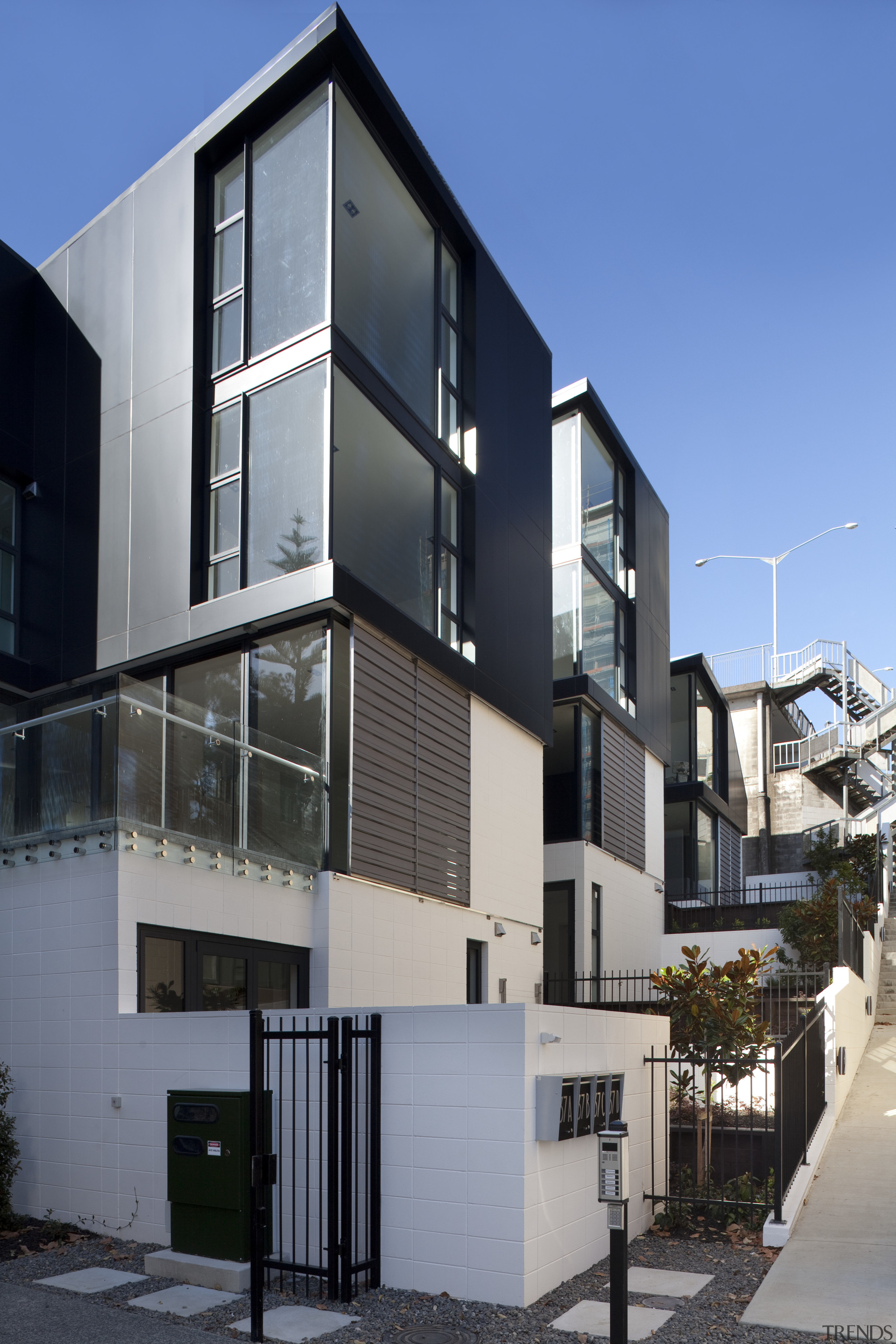 View of exterior with dark and white walls. apartment, architecture, building, condominium, elevation, facade, home, house, mixed use, neighbourhood, real estate, residential area, window, gray, black