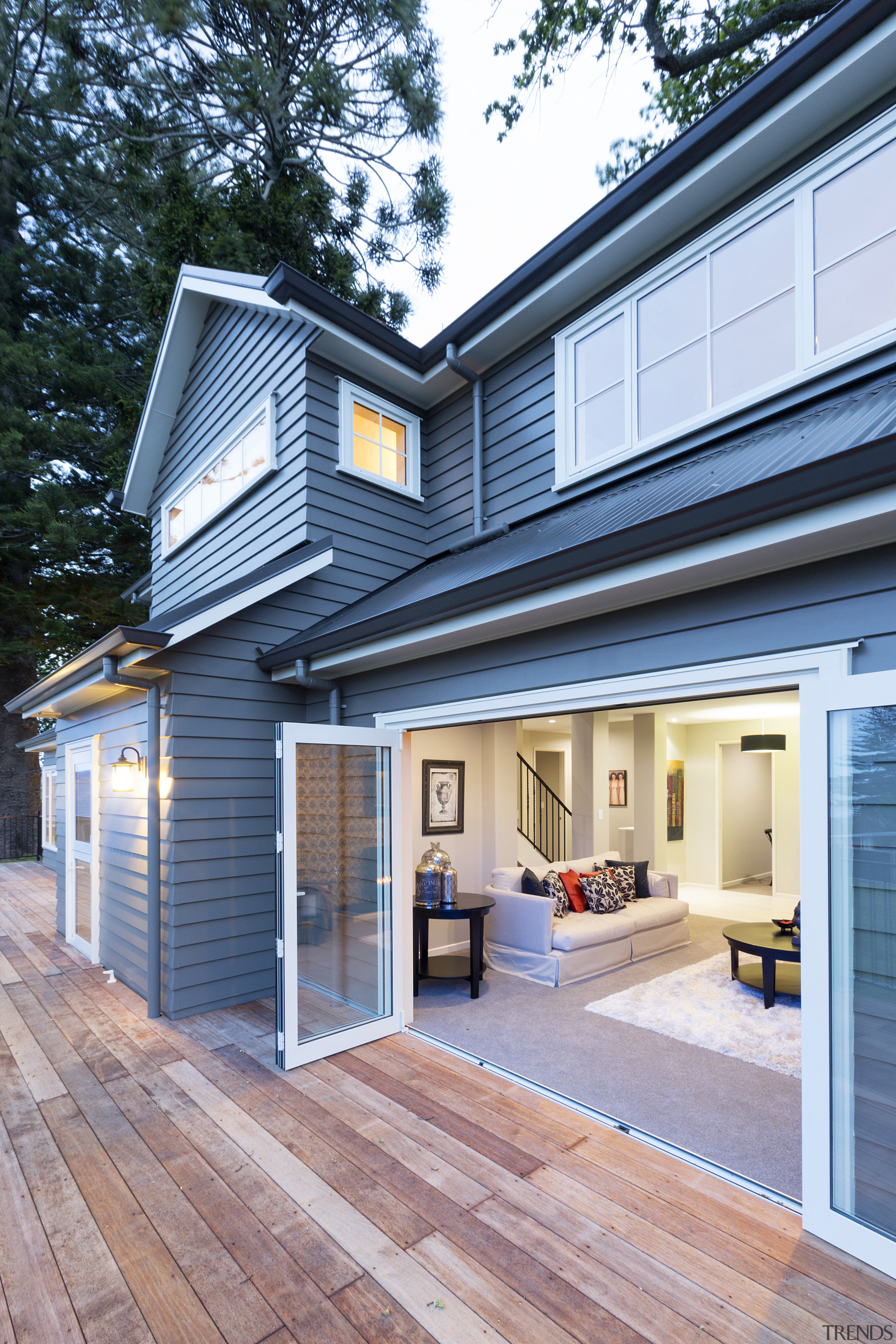 Bifolding doors open up to an expansive deck facade, home, house, real estate, roof, siding, window, teal