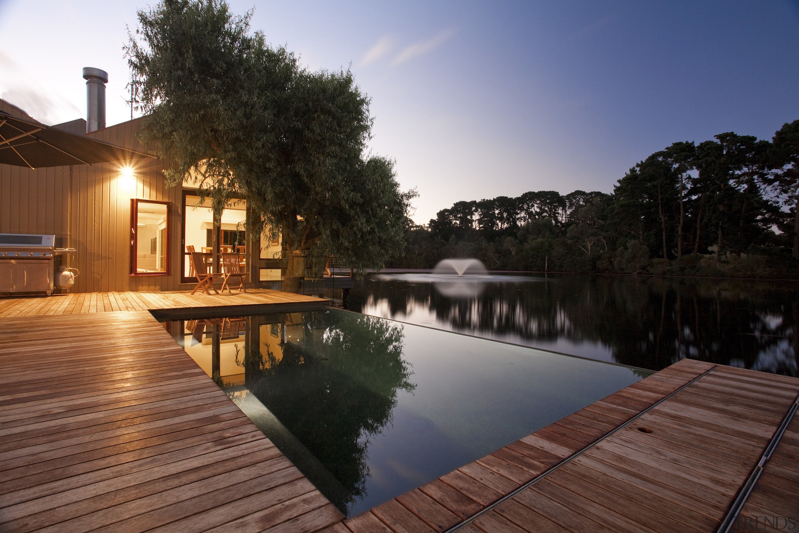 View of pool and patio area. - View architecture, backyard, cottage, deck, estate, evening, home, house, landscape, landscape lighting, leisure, lighting, outdoor structure, plant, property, real estate, reflecting pool, reflection, residential area, resort, sky, sunlight, swimming pool, tree, villa, water, red, black