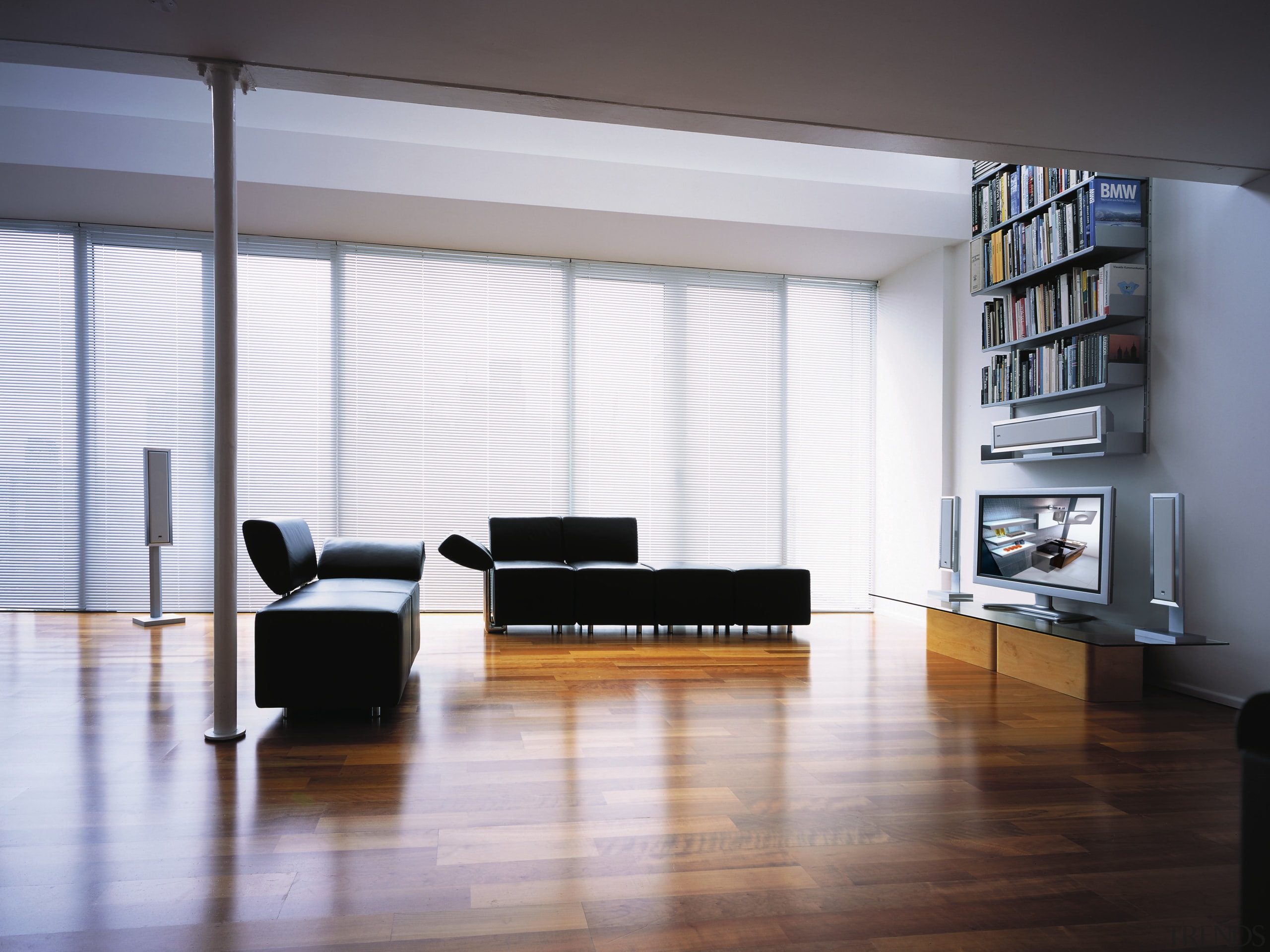 View of lounge room with home theatre systems, architecture, chair, floor, flooring, furniture, interior design, living room, loft, table, wall, window, gray