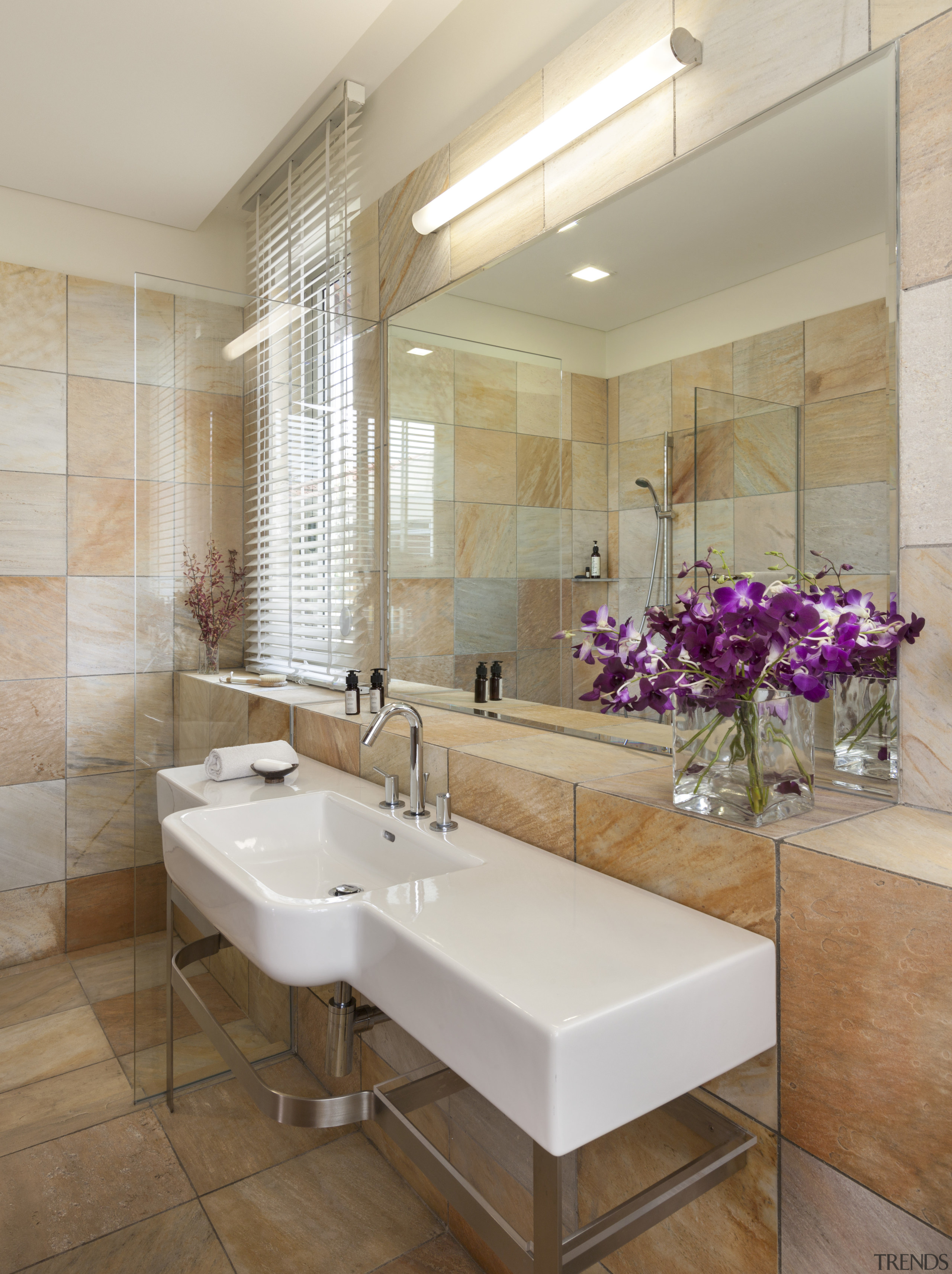 The bathroom in this home is lined with bathroom, floor, flooring, home, interior design, real estate, room, sink, tile, wall, gray, brown