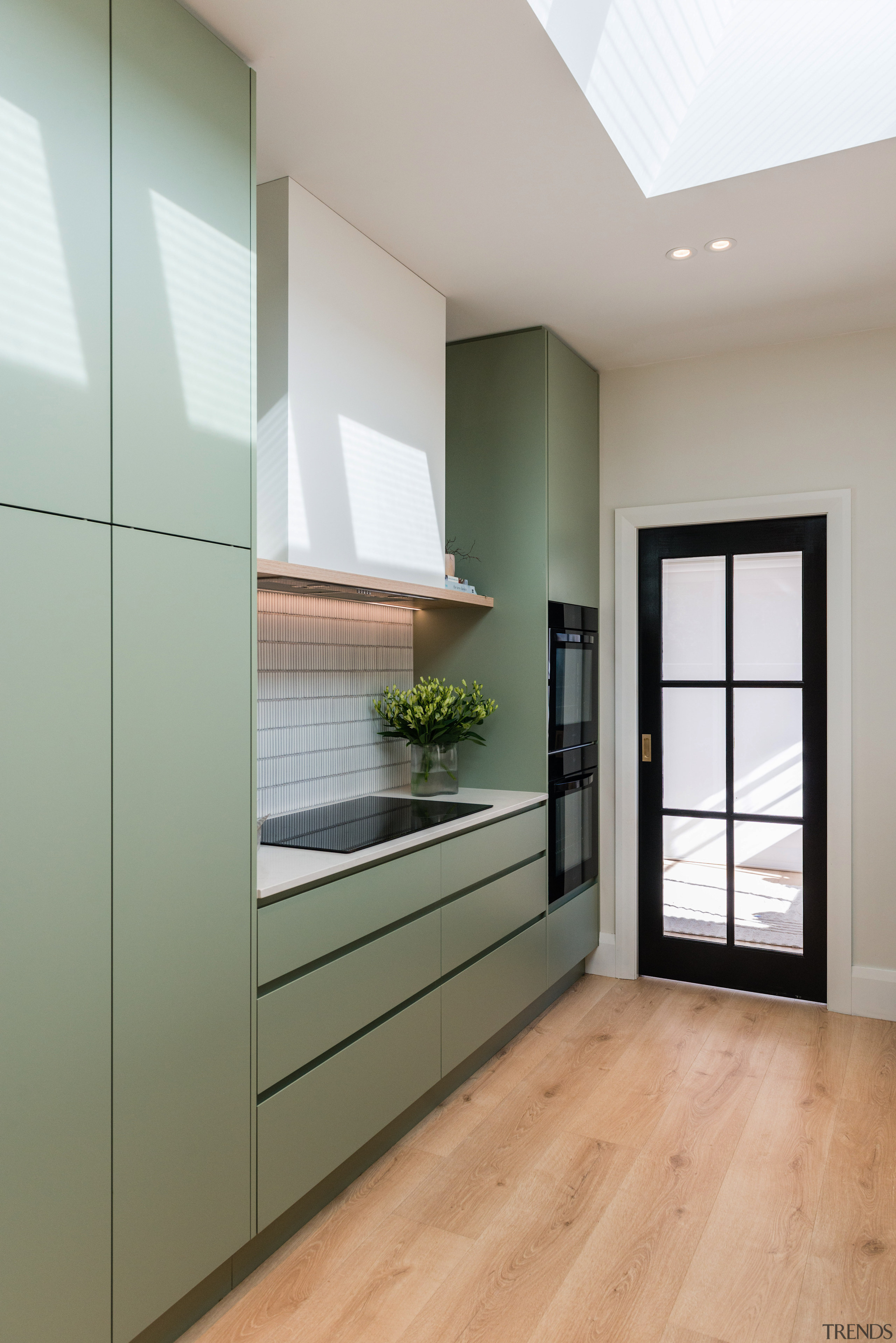 Green cabinetry works well with wood look flooring. 