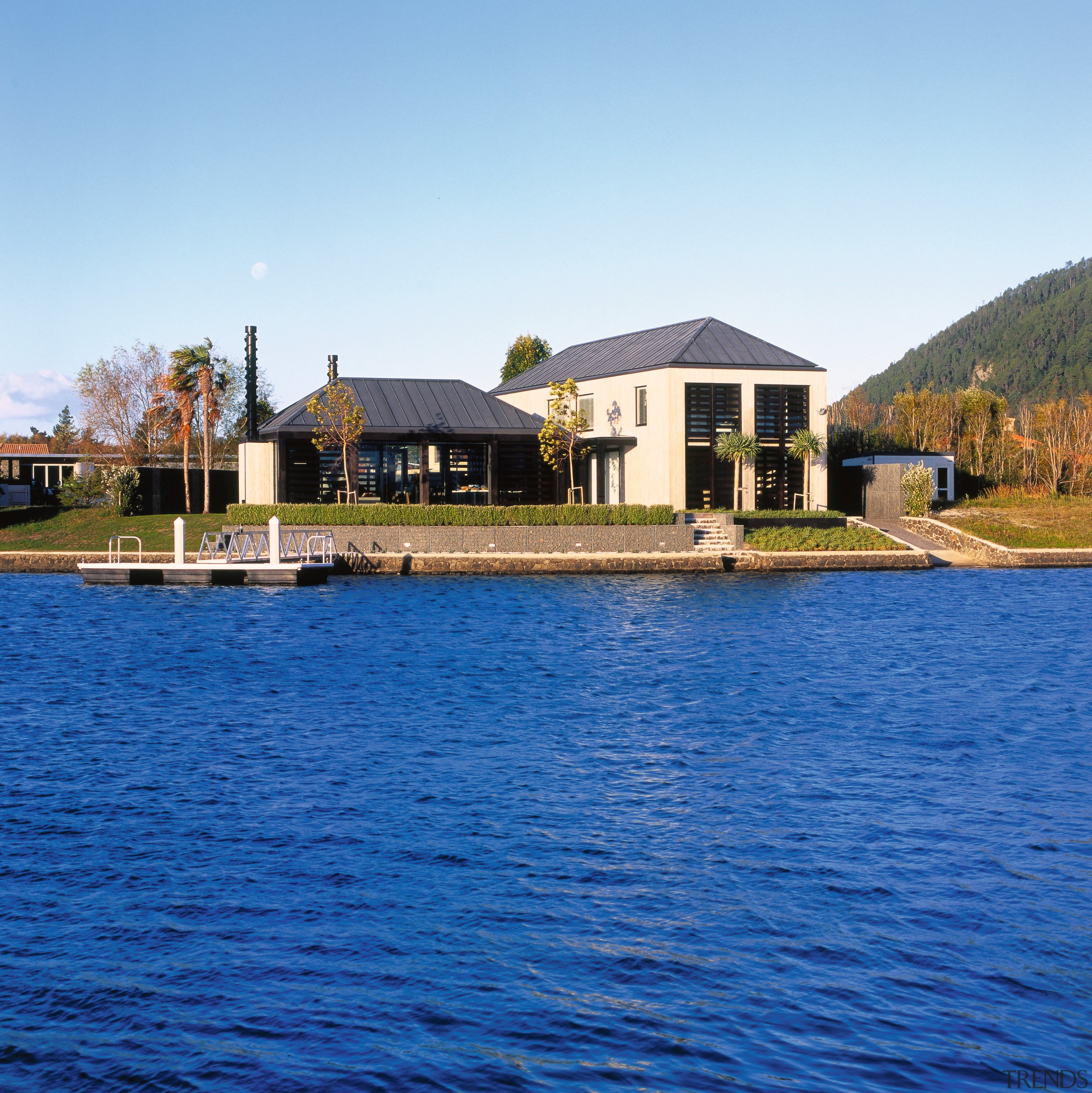 view of the house consiting of two forms cottage, estate, home, house, lake, mansion, property, real estate, reflection, reservoir, resort, sky, villa, water, waterway, blue