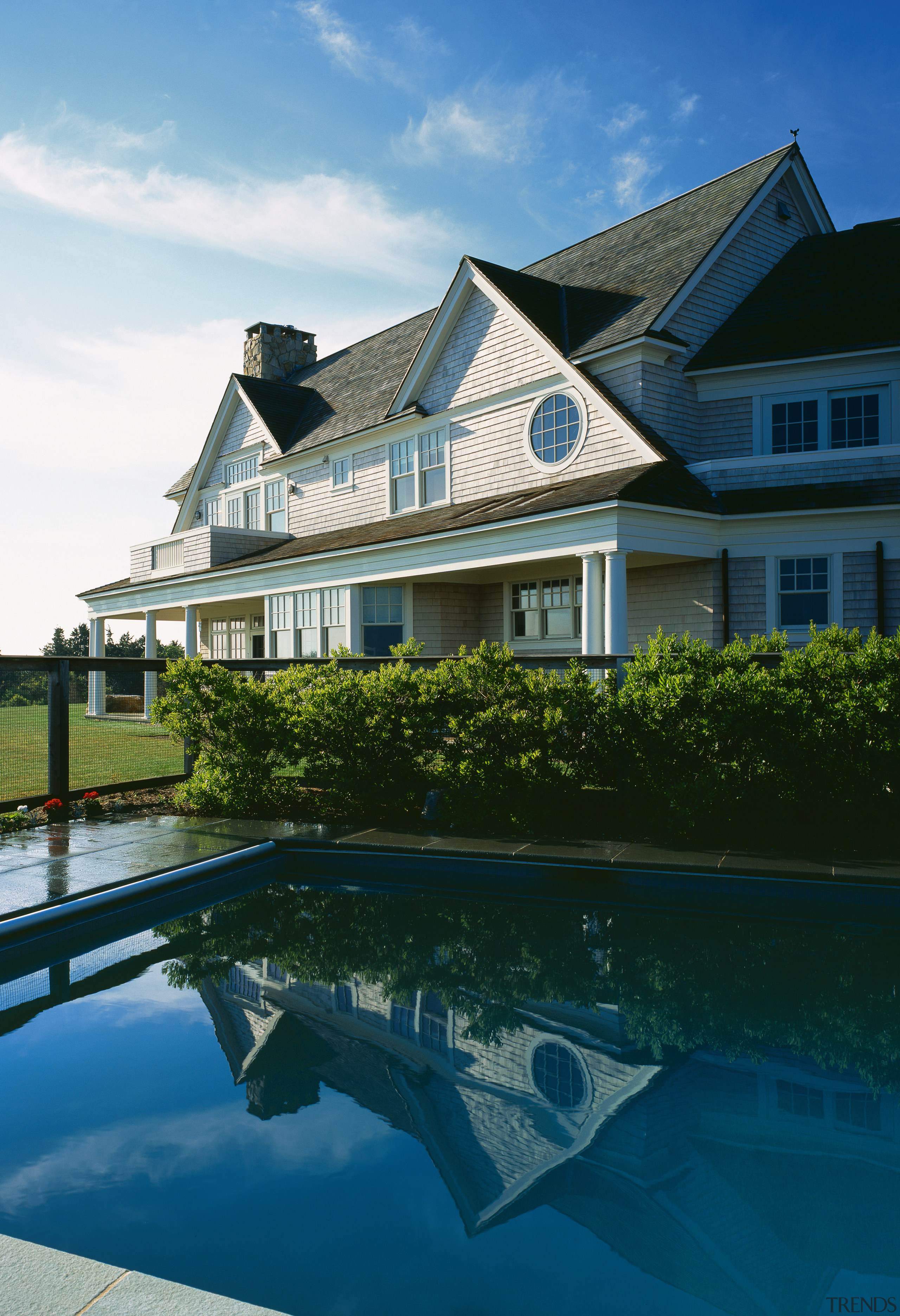 Exterior view of large house with weatherboard cladding, architecture, building, cottage, estate, home, house, mansion, property, real estate, reflection, residential area, roof, sky, swimming pool, villa, water, teal