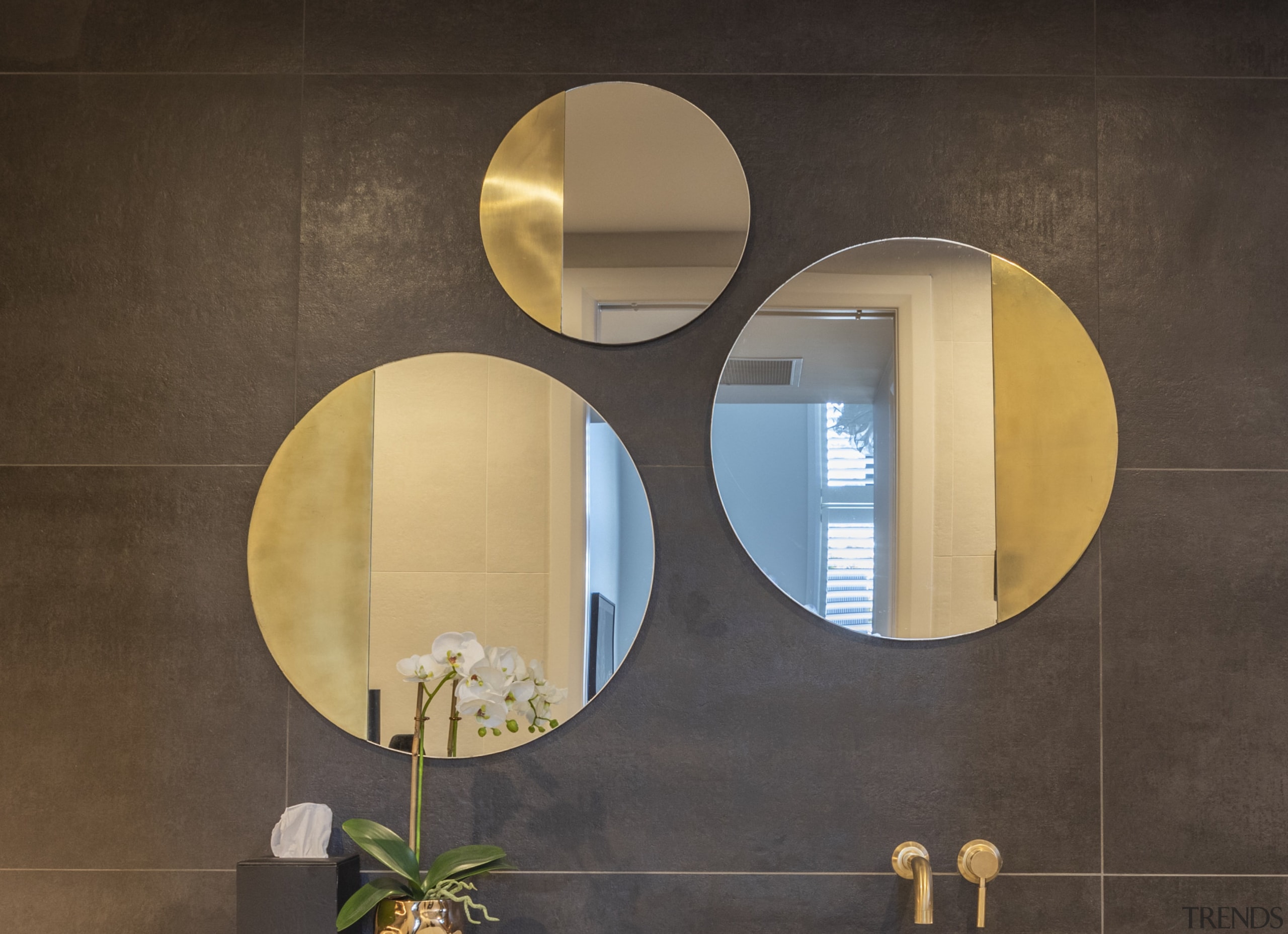 The three circular wall mirrors are framed in 