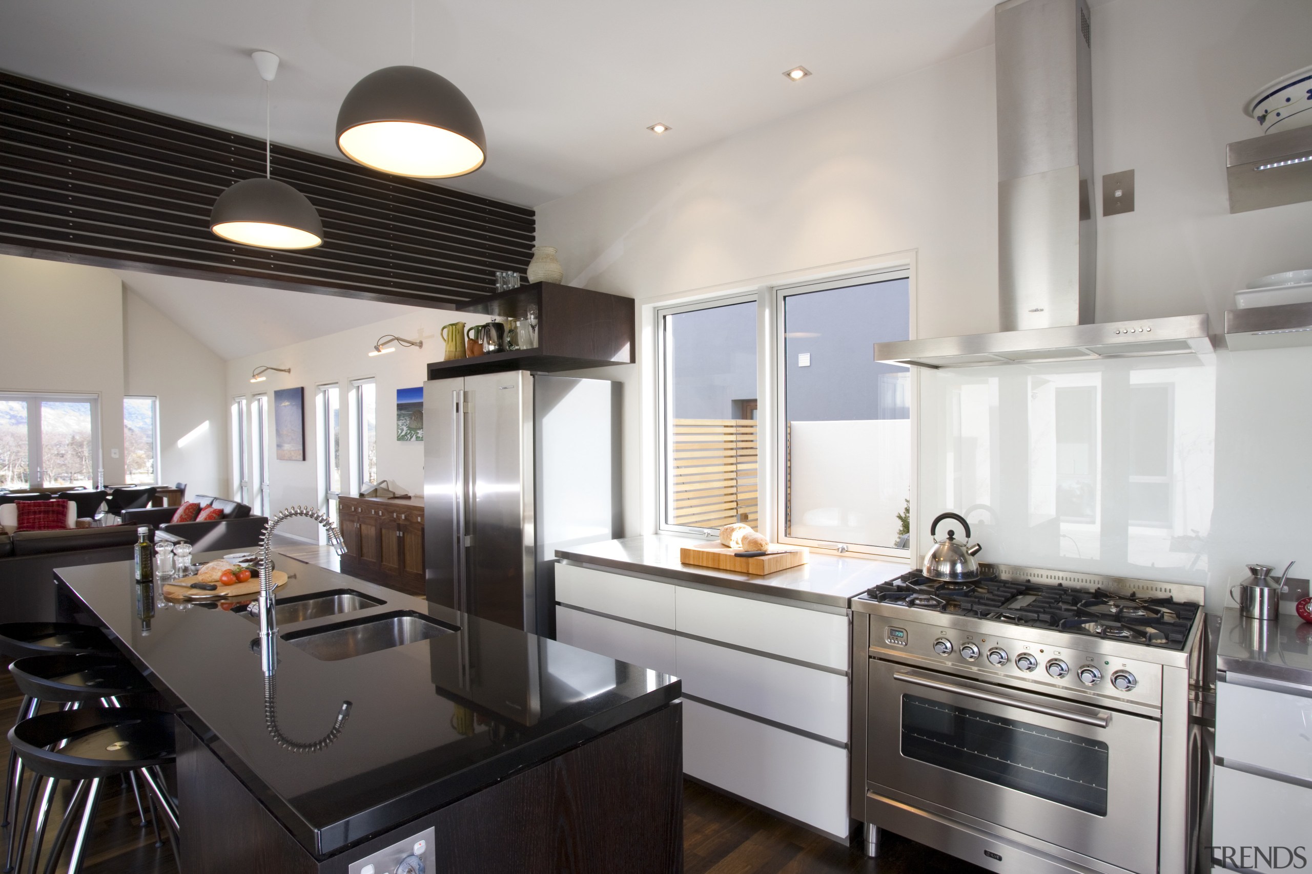 View of kitchen and living area designed by countertop, interior design, kitchen, real estate, gray, black