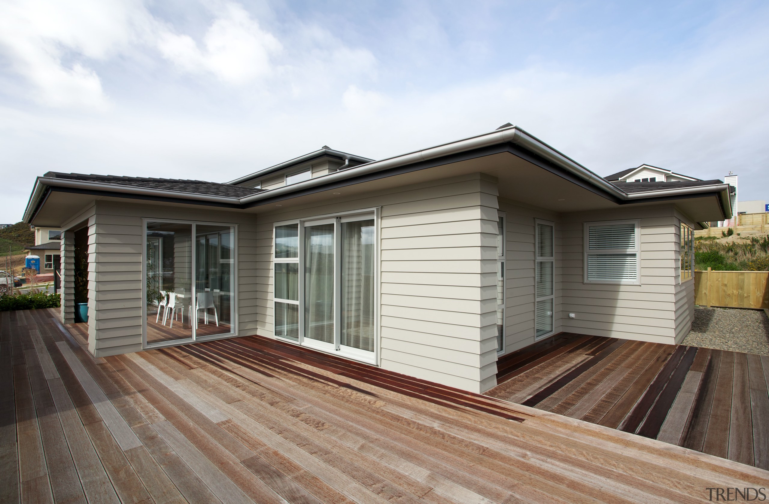 The large wood deck of this show home elevation, estate, facade, home, house, property, real estate, residential area, roof, siding, window, white