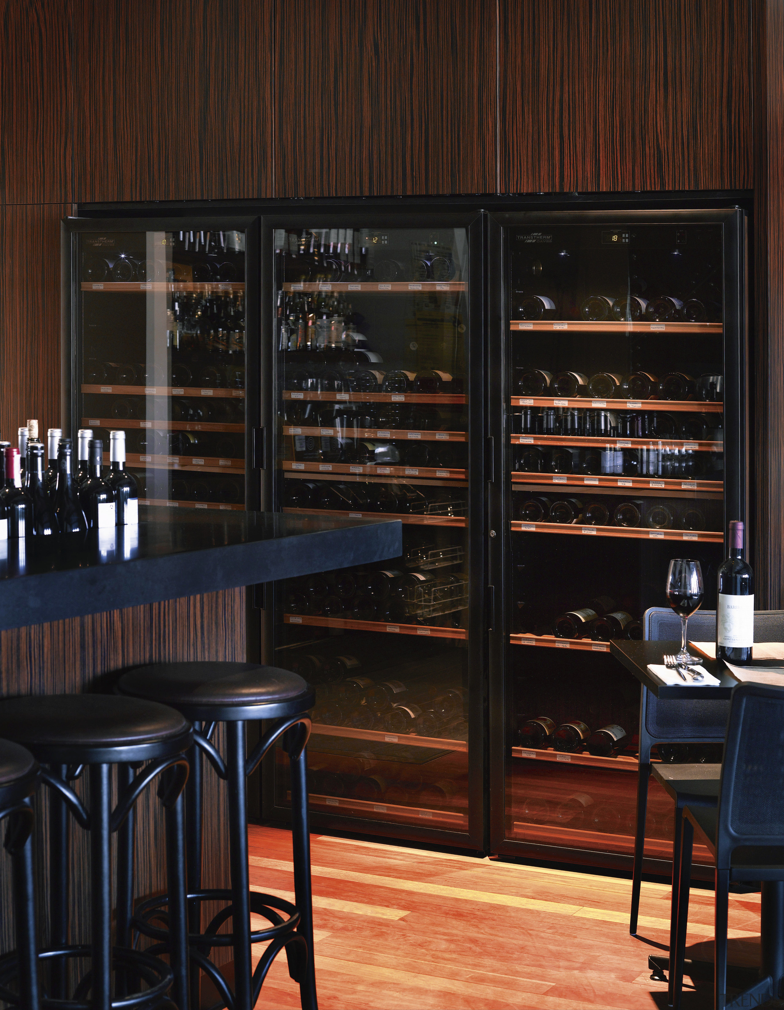This eatery and wine bar displays a broad furniture, interior design, liquor store, restaurant, wine cellar, black
