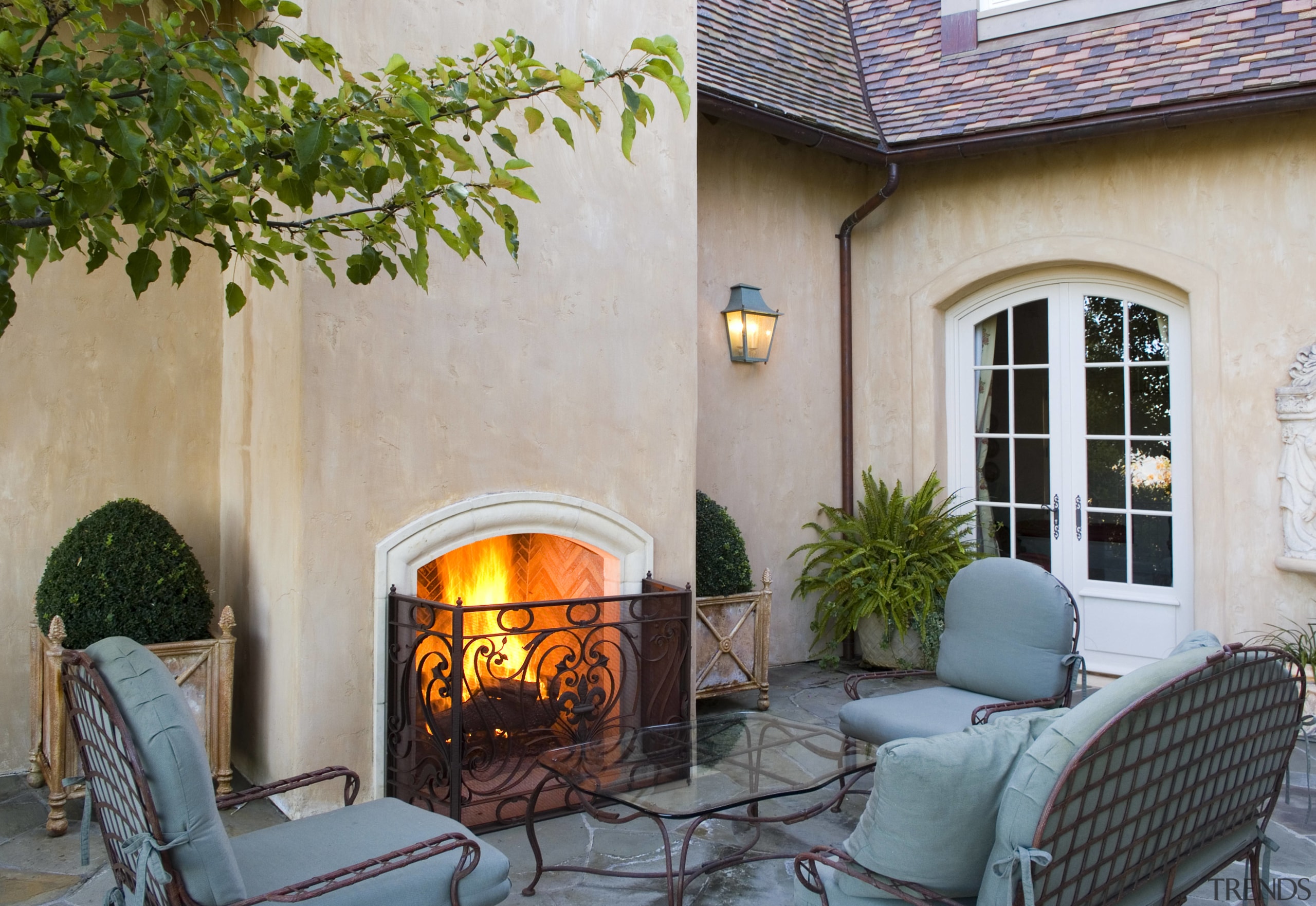 View of patio, outdoor furniture, fireplace, Plaster walls, backyard, courtyard, fireplace, hearth, home, house, interior design, living room, outdoor structure, patio, real estate, wood burning stove, gray