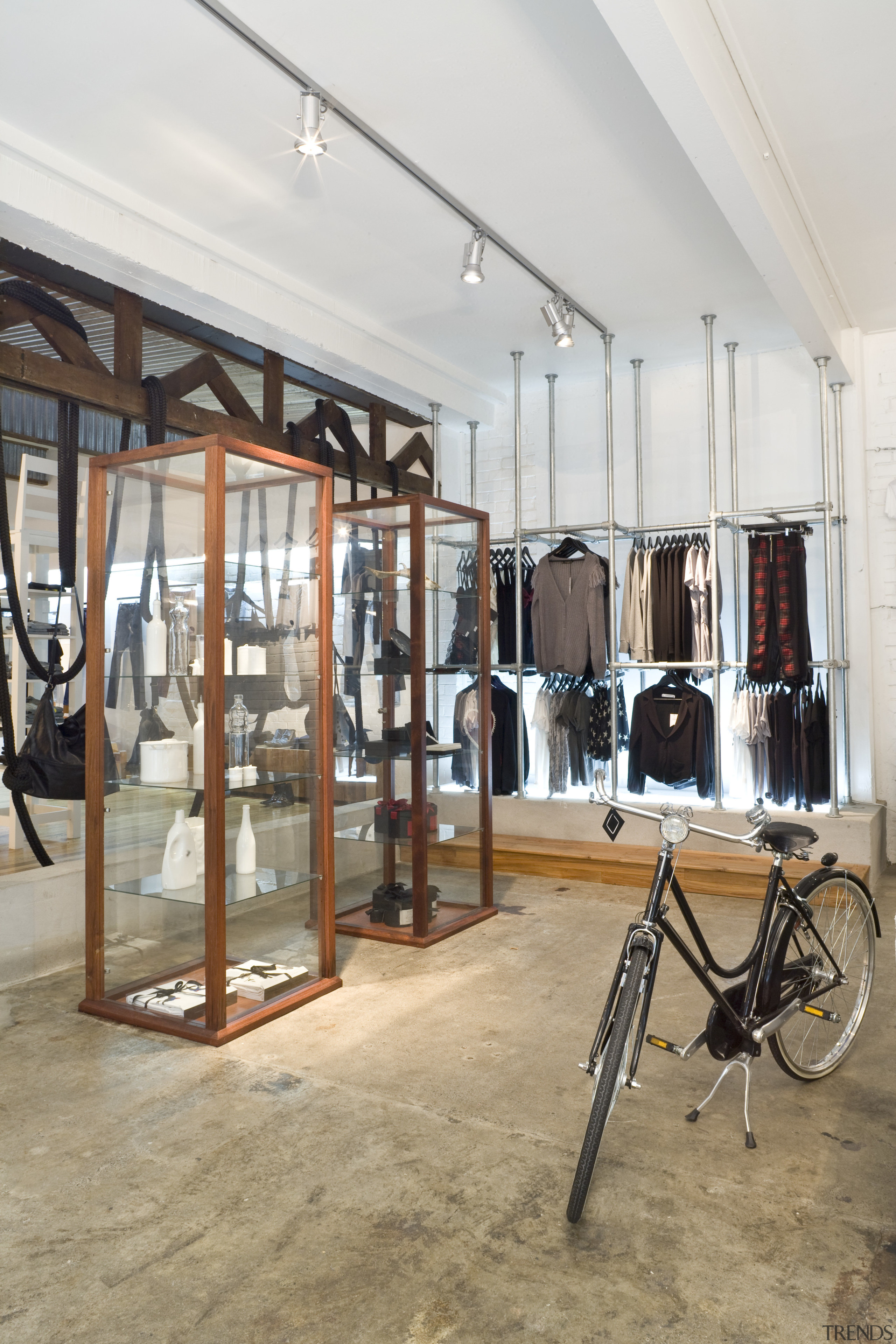 View of clothing displays which are separated by boutique, flooring, structure, white