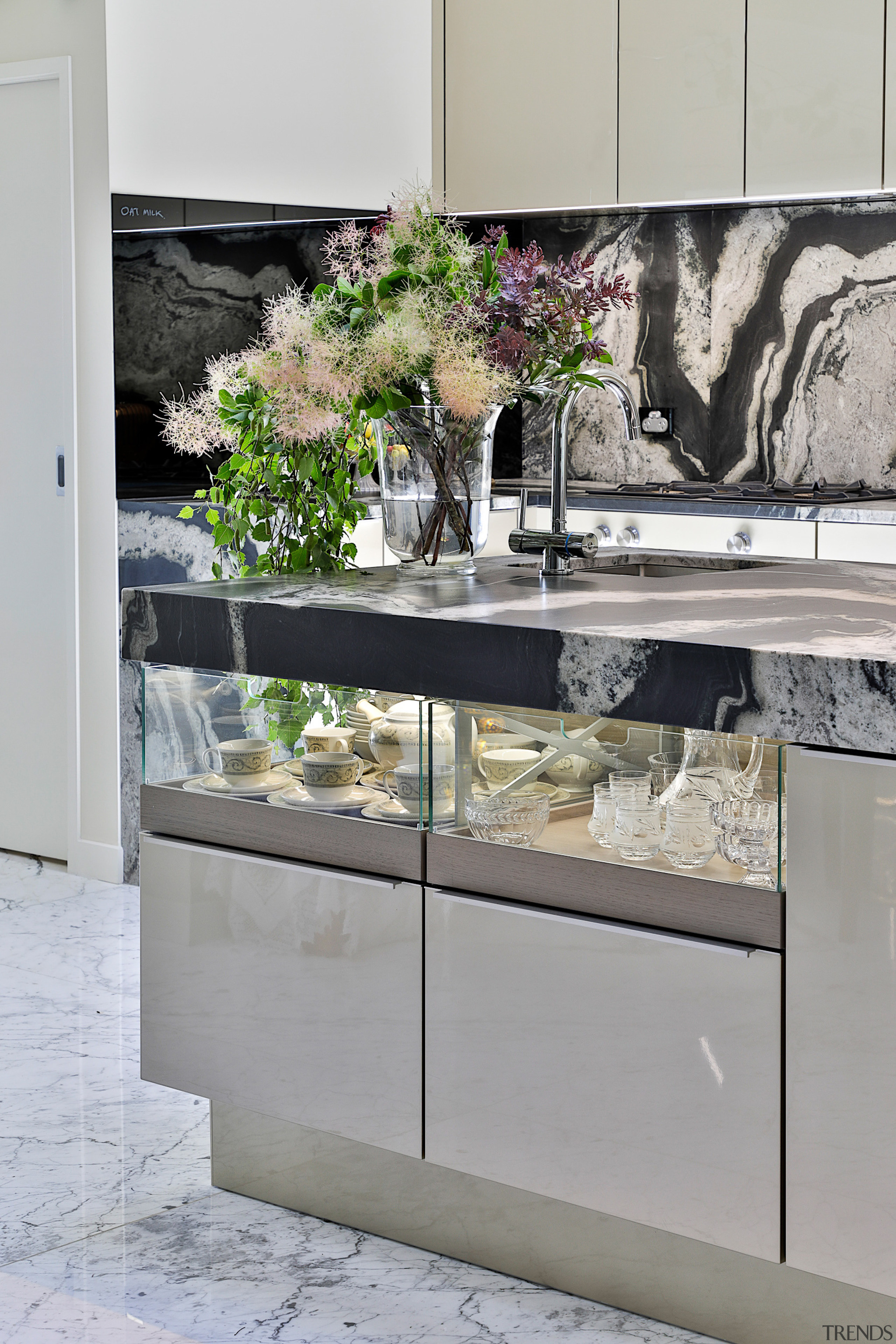 Glass-fronted display storage fronts the kitchen's sizeable island. 