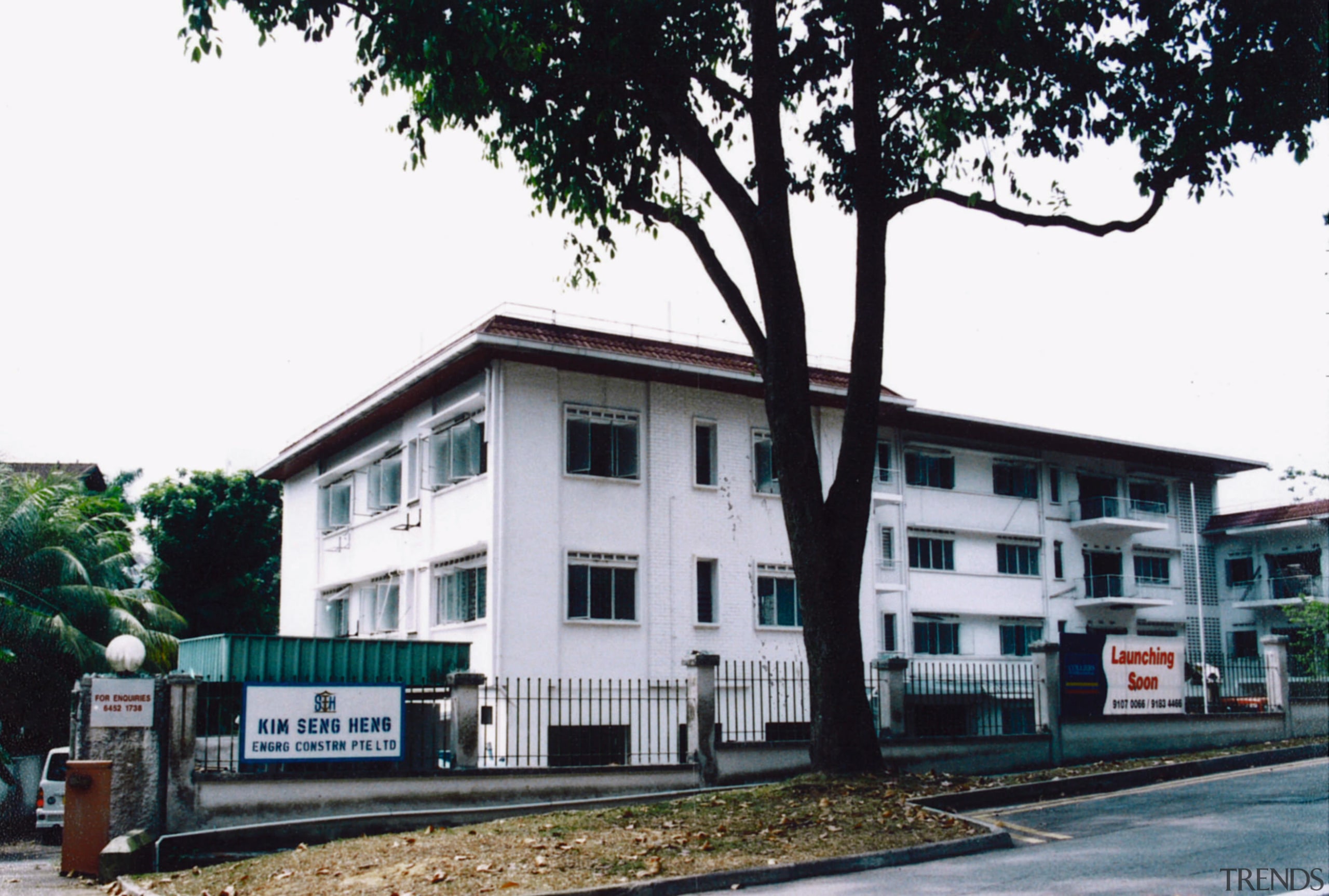 A view of the apartments before they were building, facade, home, house, property, real estate, tree, white, black