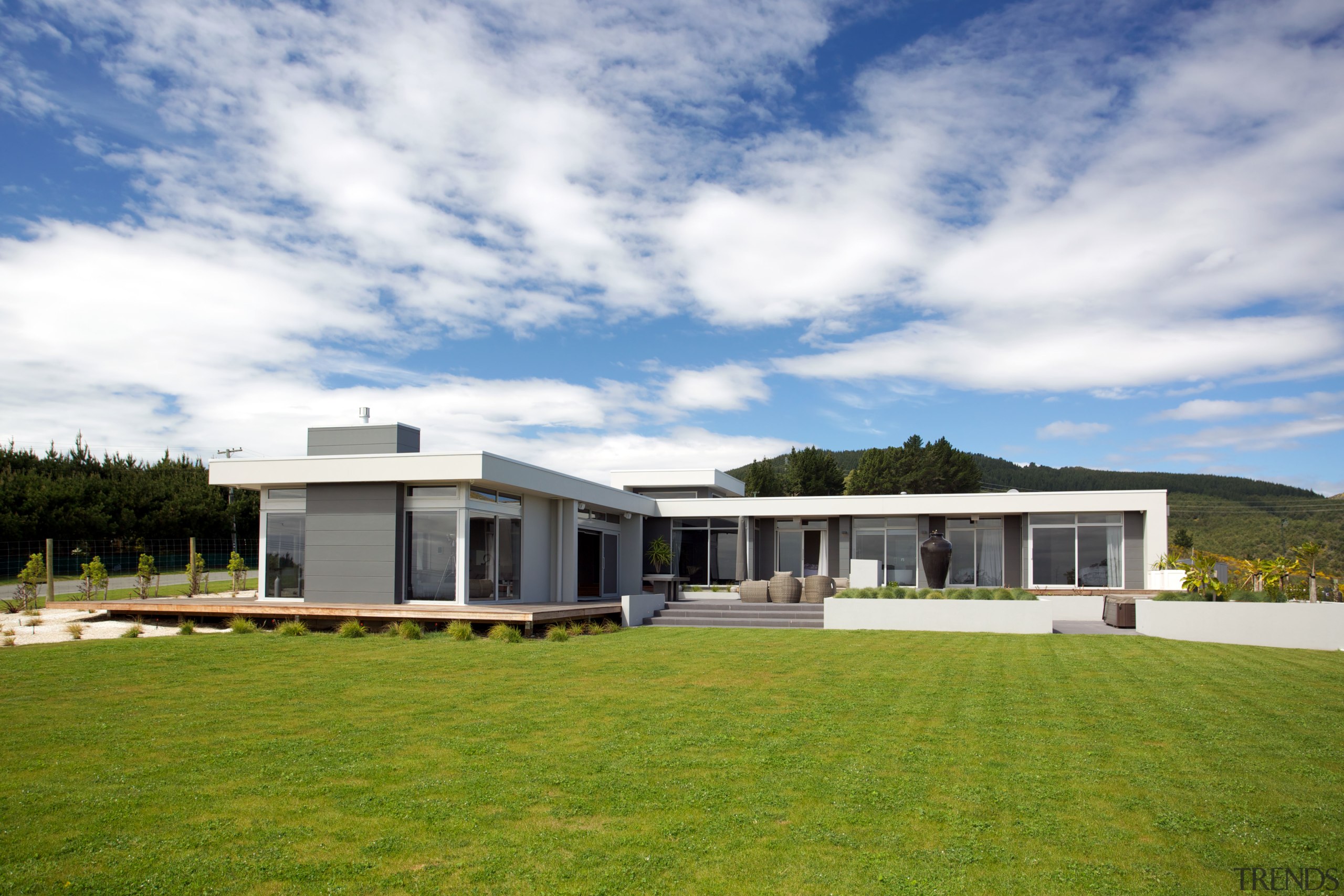 Open to the suns warmth but closed off architecture, cloud, corporate headquarters, cottage, elevation, estate, facade, farmhouse, grass, home, house, land lot, landscape, property, real estate, residential area, sky, villa, white