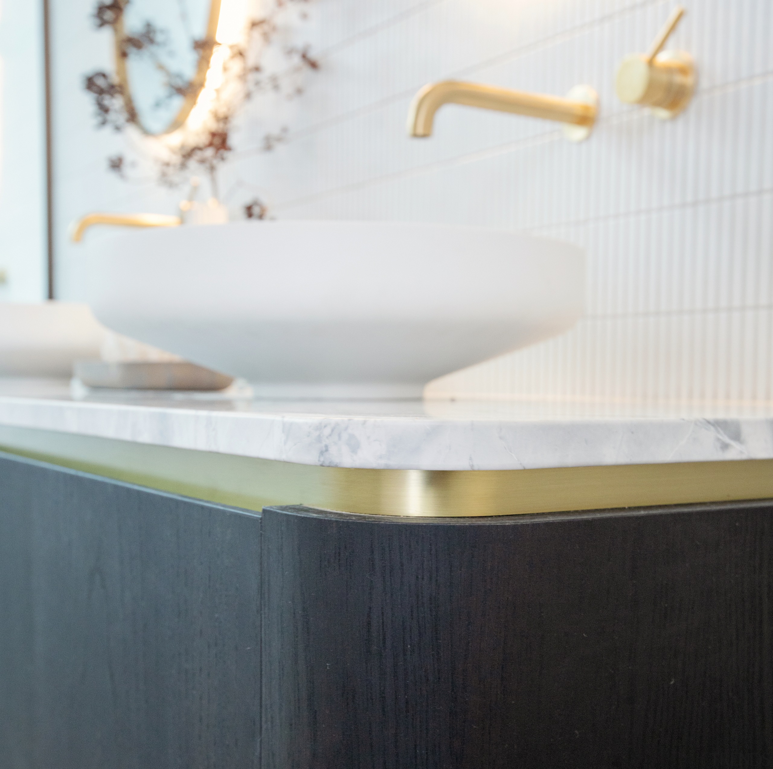 Brushed brass accents feature on the vanity. 