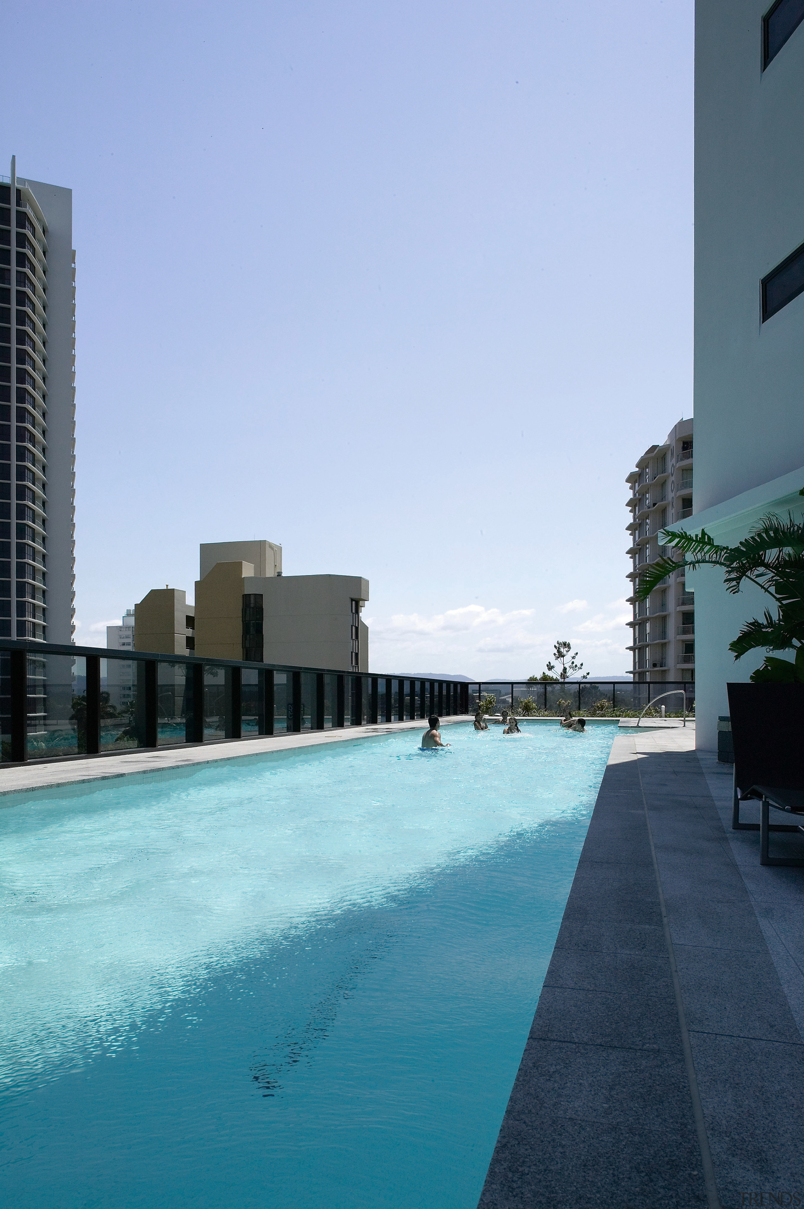 A view of the outdoor pool at the architecture, building, city, condominium, daytime, metropolitan area, reflection, sea, sky, skyscraper, swimming pool, vacation, water, teal