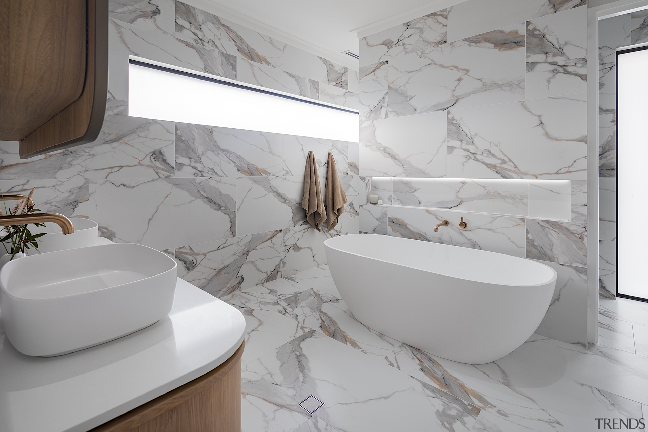 Rounded tub and basin in a marble-look context. 