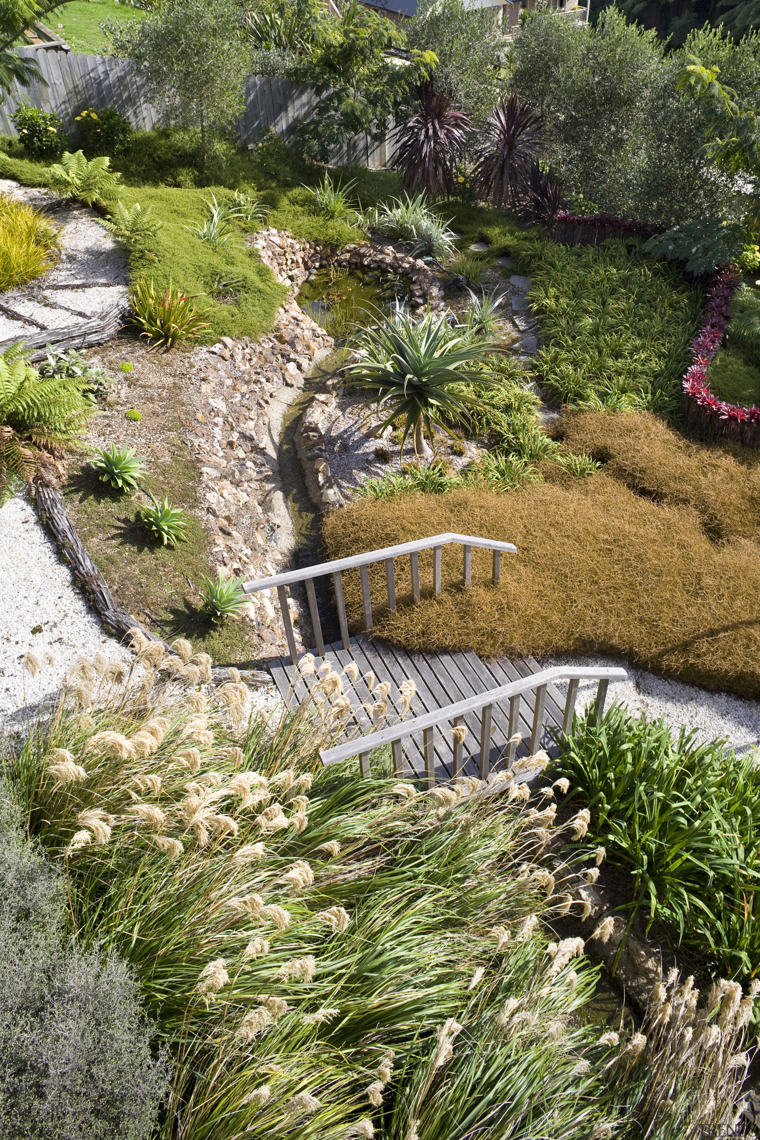 View of a landscaped garden which features a botanical garden, flower, garden, grass, grass family, landscape, landscaping, plant, vegetation, walkway, water, watercourse, yard, brown