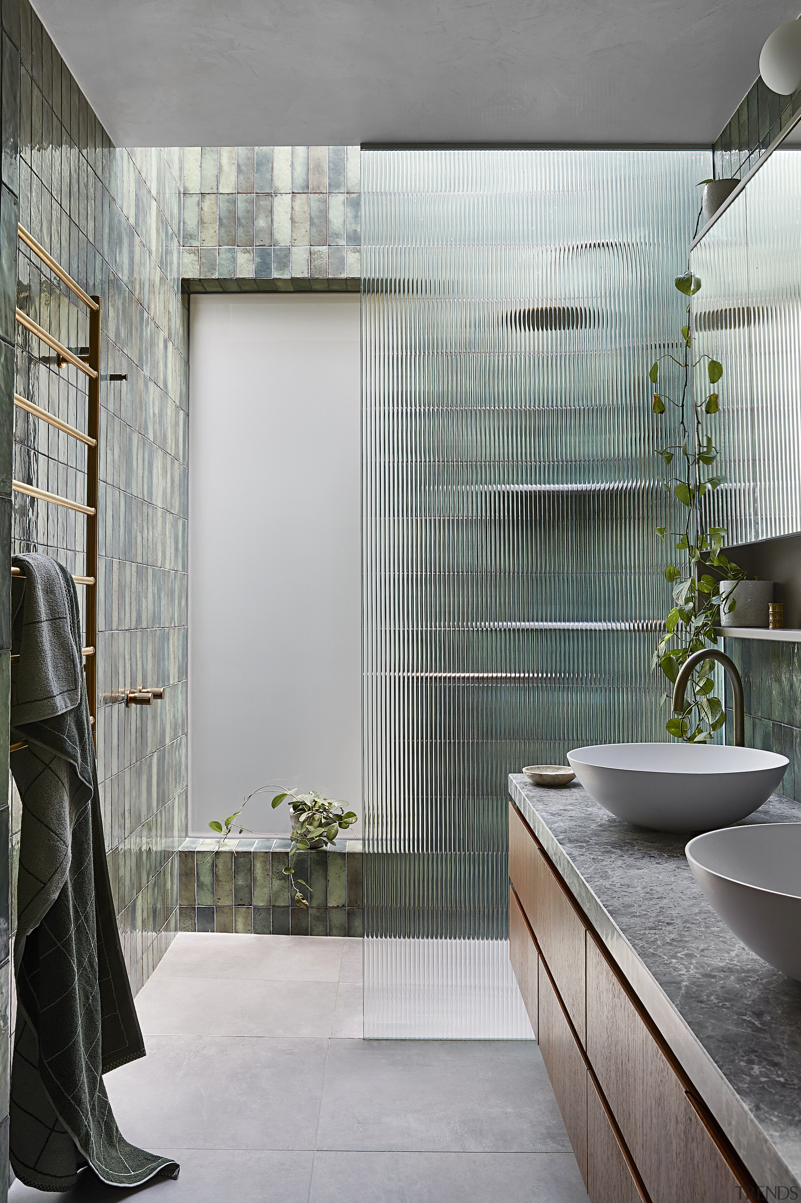 A fluted glass wall separates the shower from 