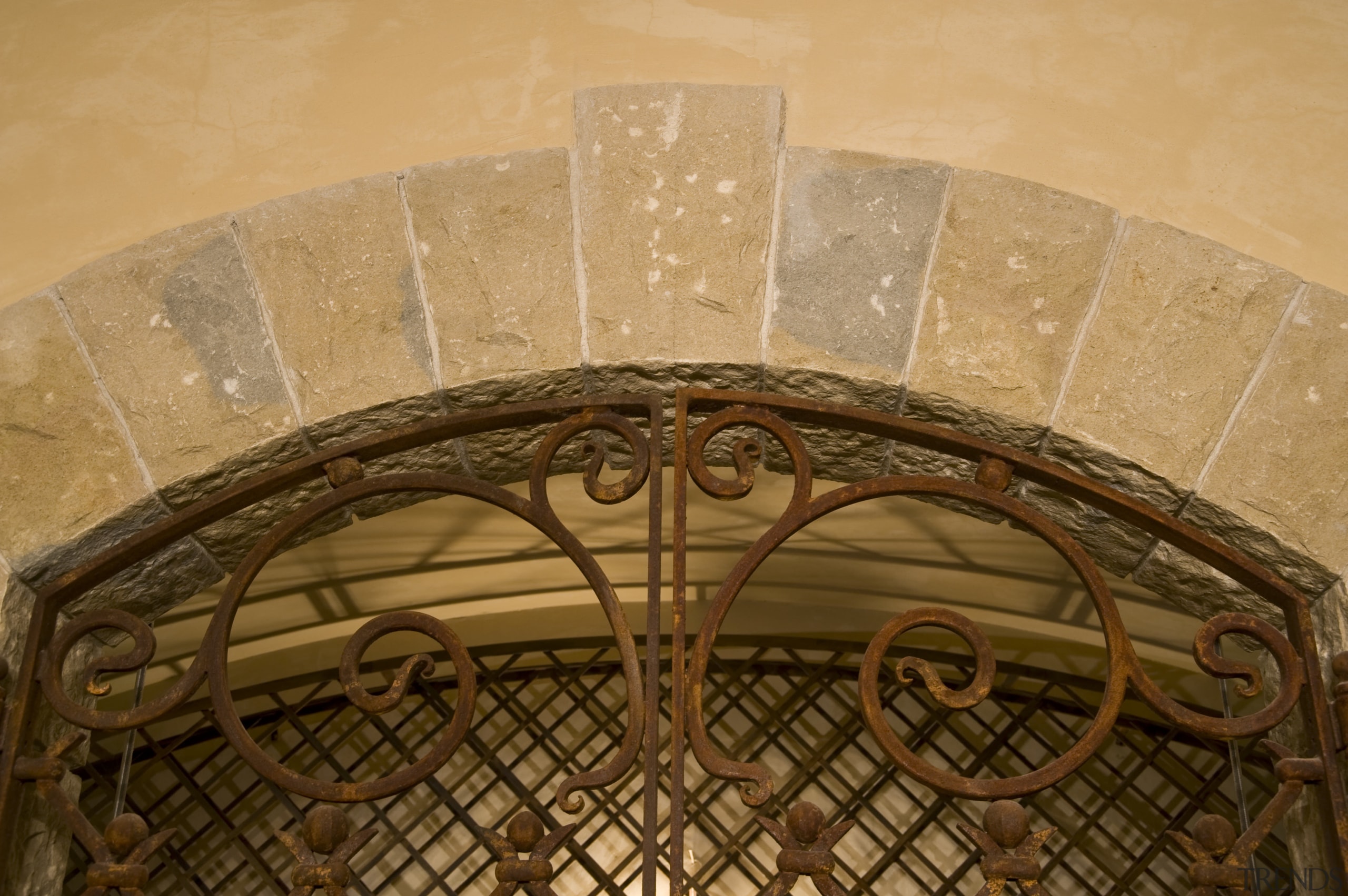 View of a wine cellar which features limestone arch, carving, ceiling, orange, brown