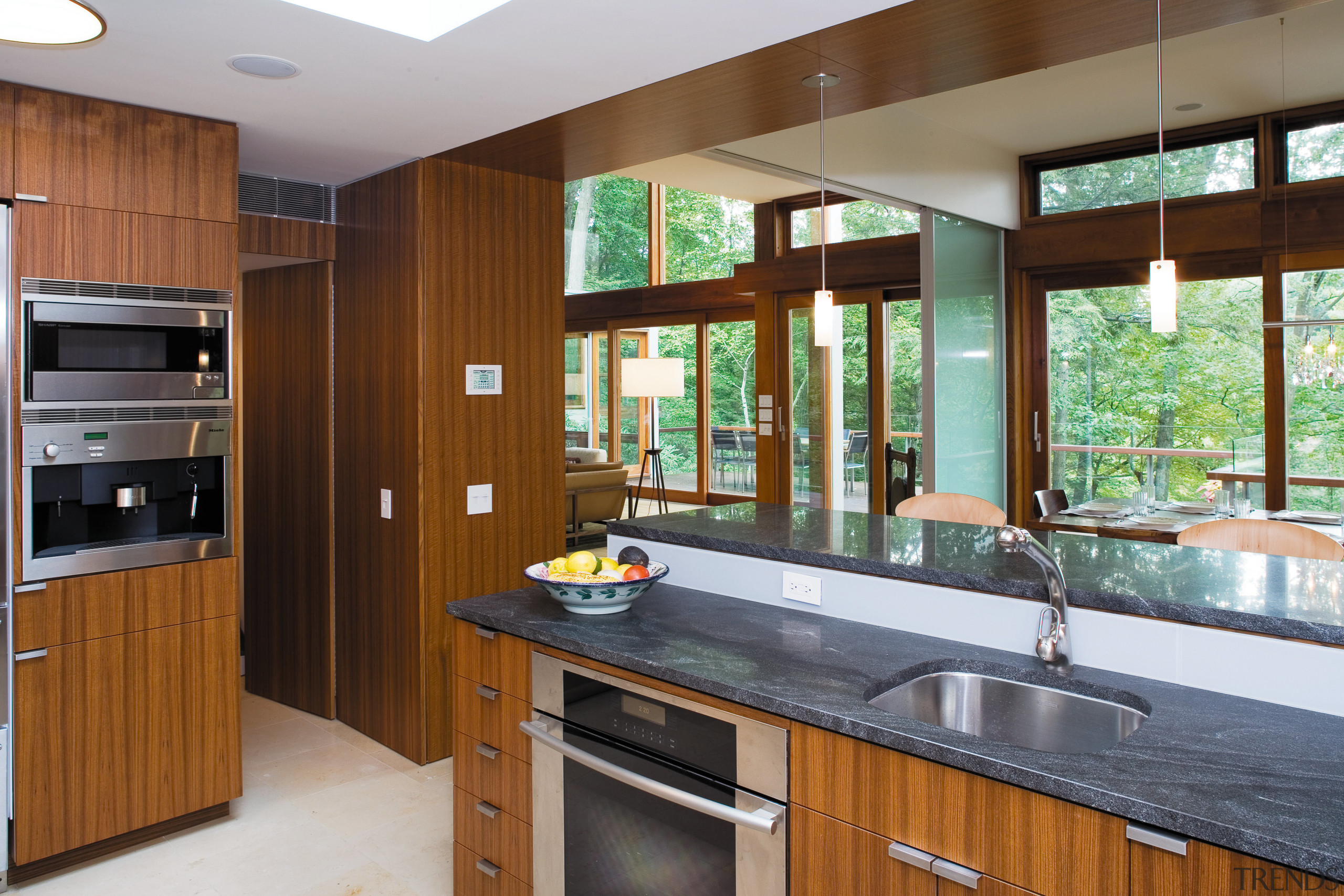 view of the kitchen dining area featuring teak cabinetry, countertop, interior design, kitchen, real estate, room, brown