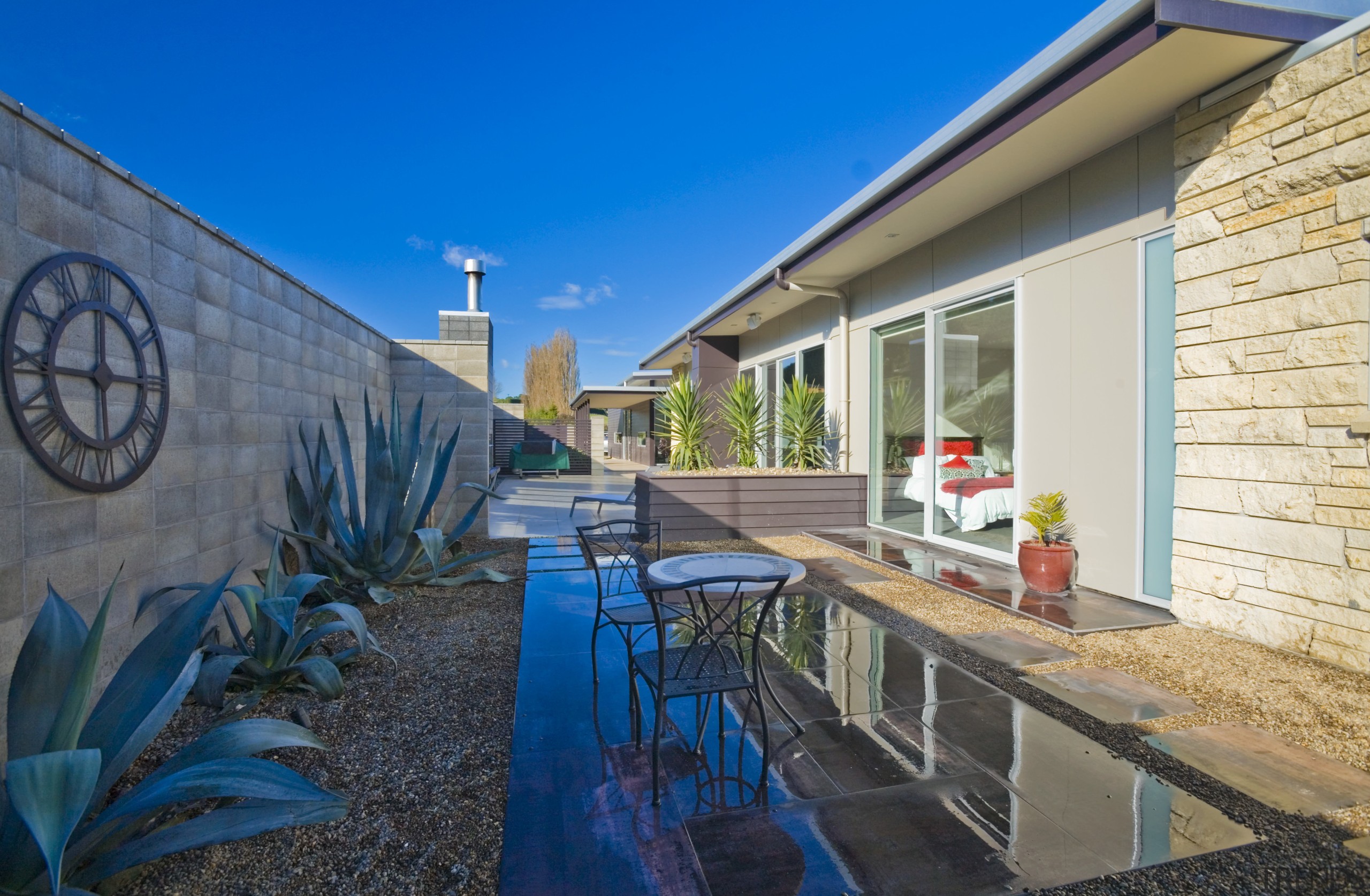 An exterior view of the patio area, concrete apartment, cottage, estate, home, house, property, real estate, villa, blue