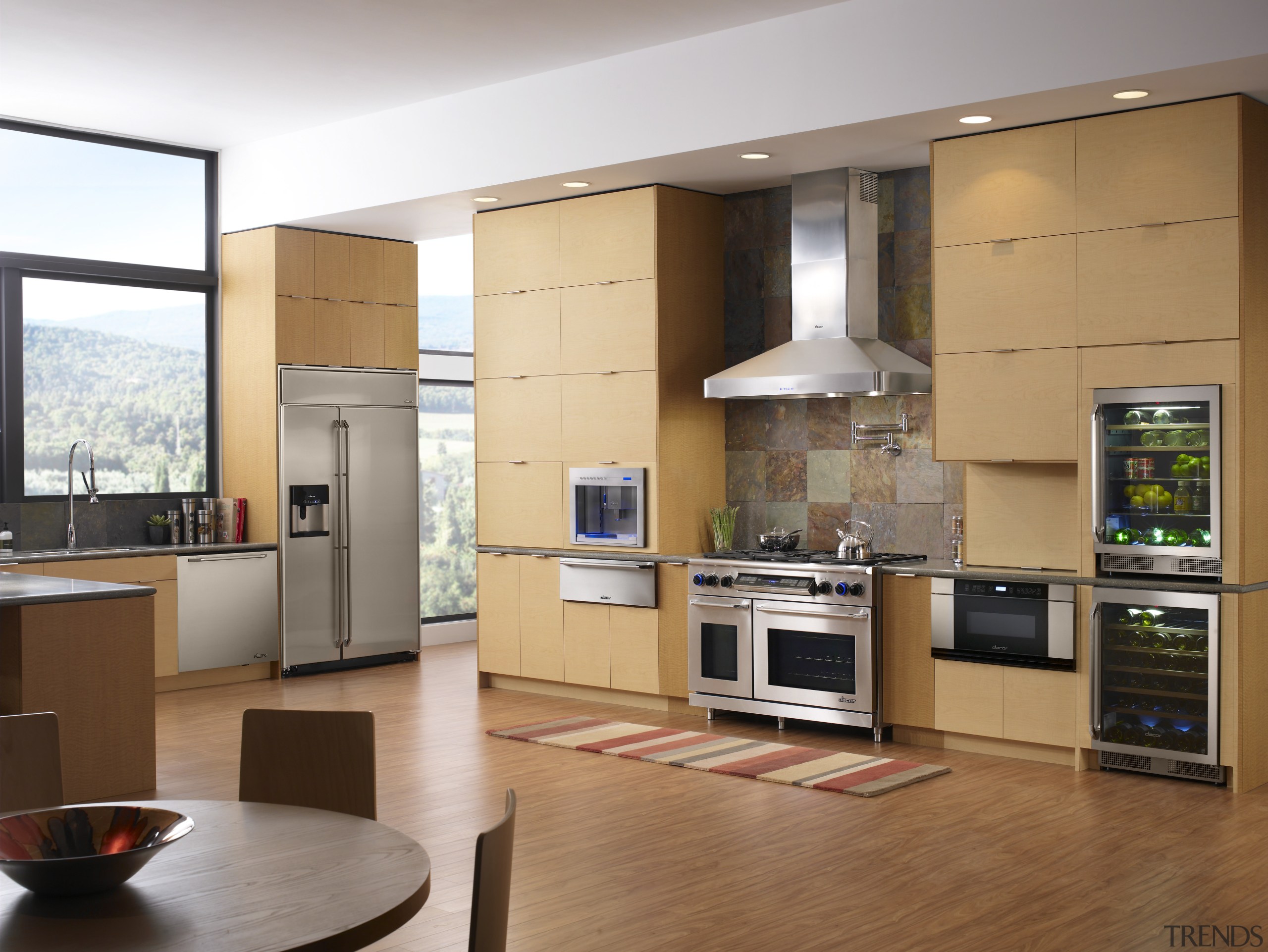 A view of this kitchen featuring the latest cabinetry, countertop, cuisine classique, floor, flooring, hardwood, home appliance, interior design, kitchen, living room, room, wood flooring, brown, gray