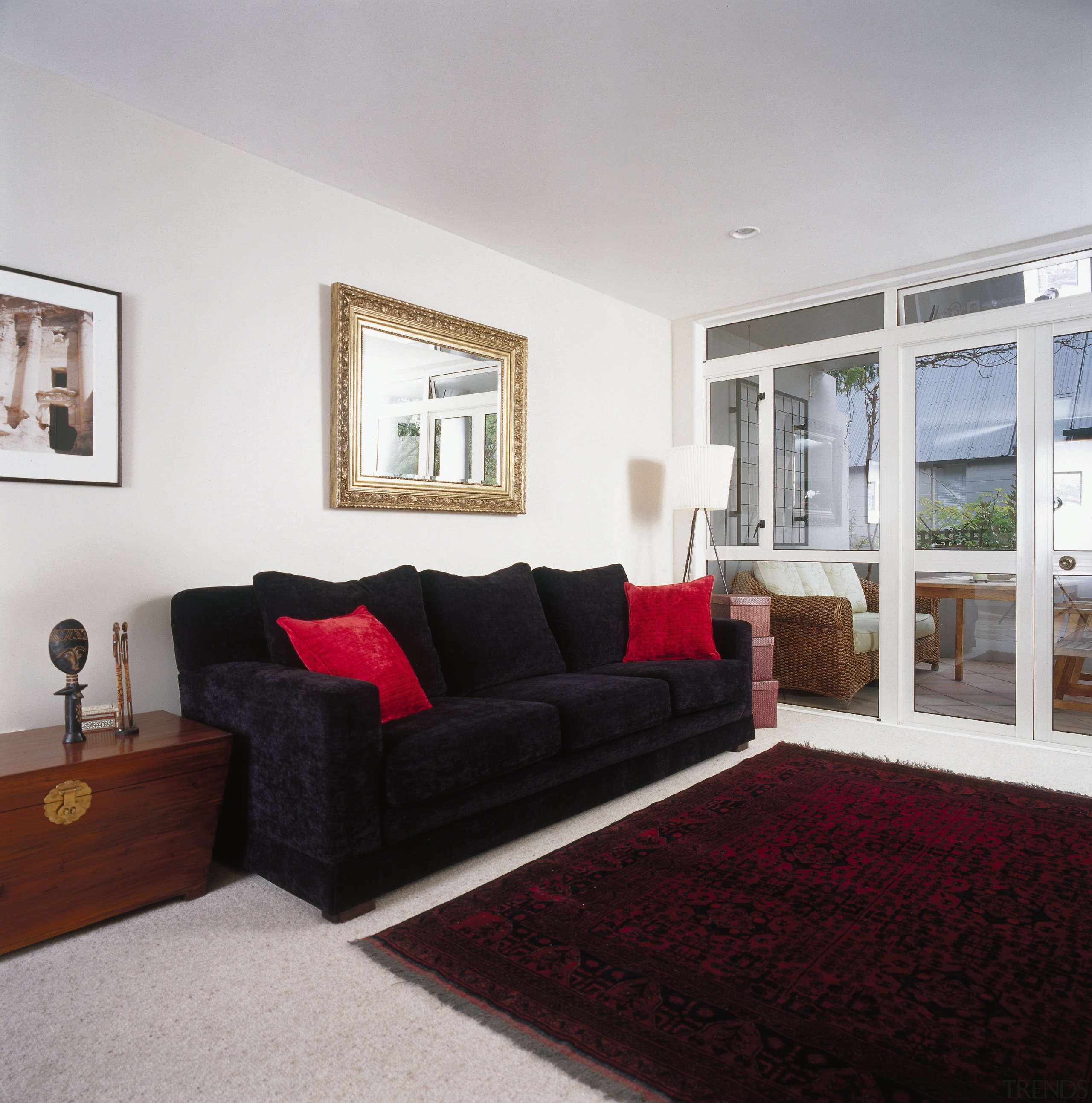 Dark sofa with red cushions in lounge room couch, floor, home, interior design, living room, property, real estate, room, window, gray, black