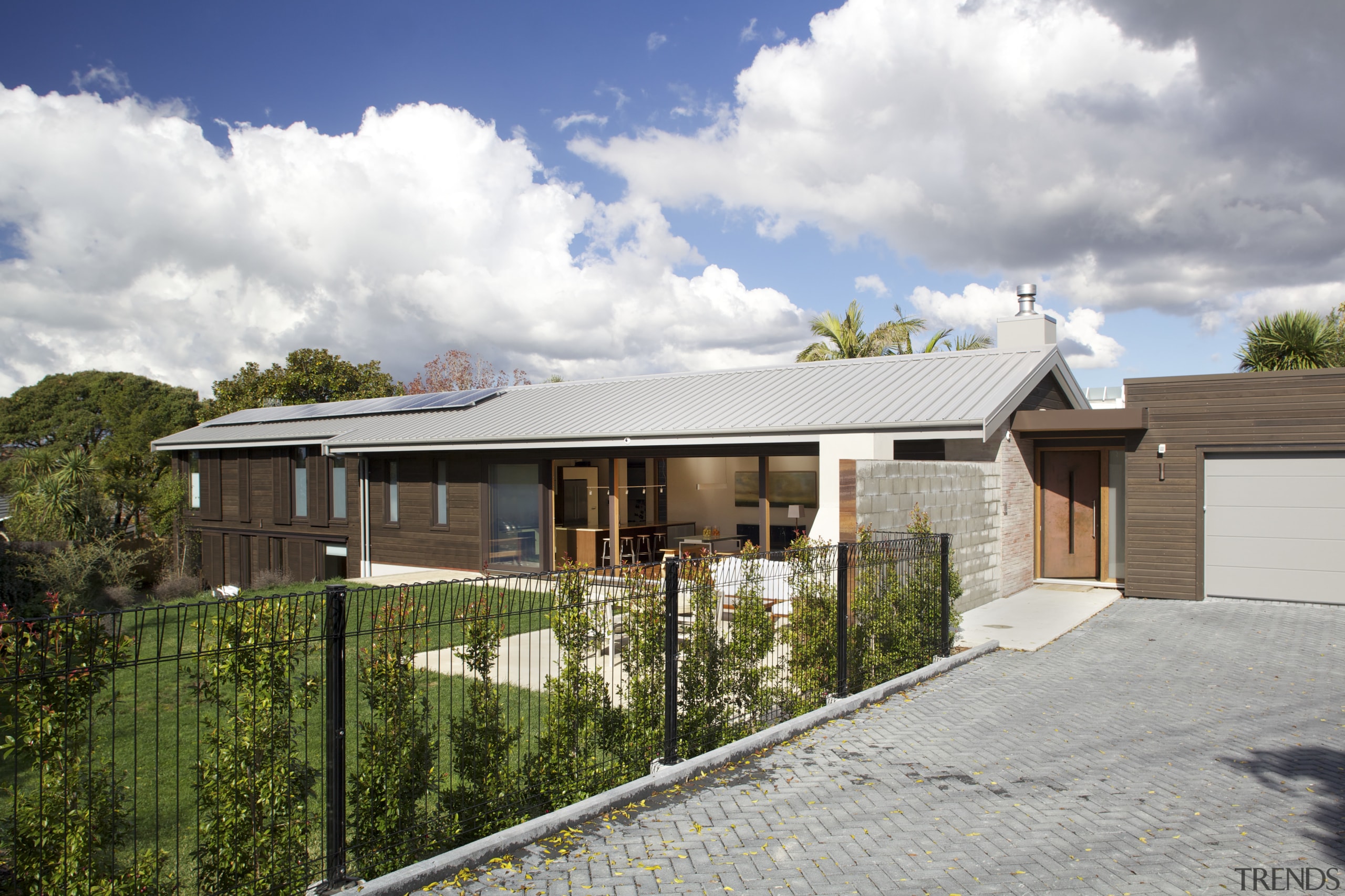Expansive north-facing glazing and solar panels on the cottage, elevation, estate, facade, home, house, property, real estate, residential area, roof, suburb, gray