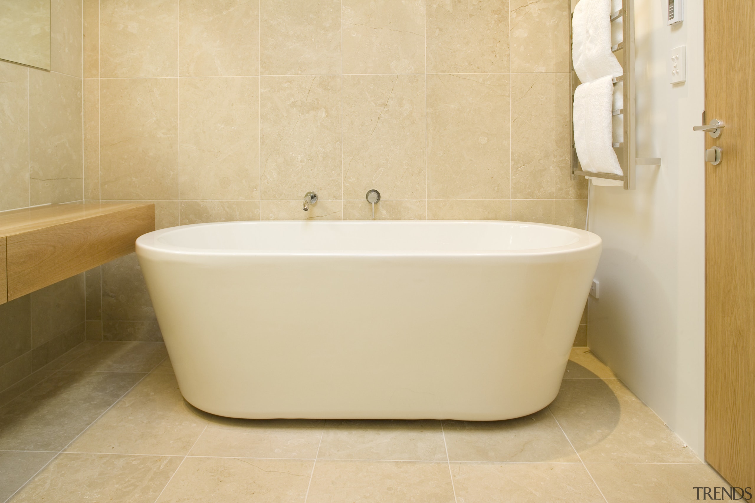 The freestanding bath functions as a piece of bathroom, bathroom sink, bathtub, ceramic, floor, flooring, interior design, plumbing fixture, product design, sink, tap, tile, toilet seat, wall, orange