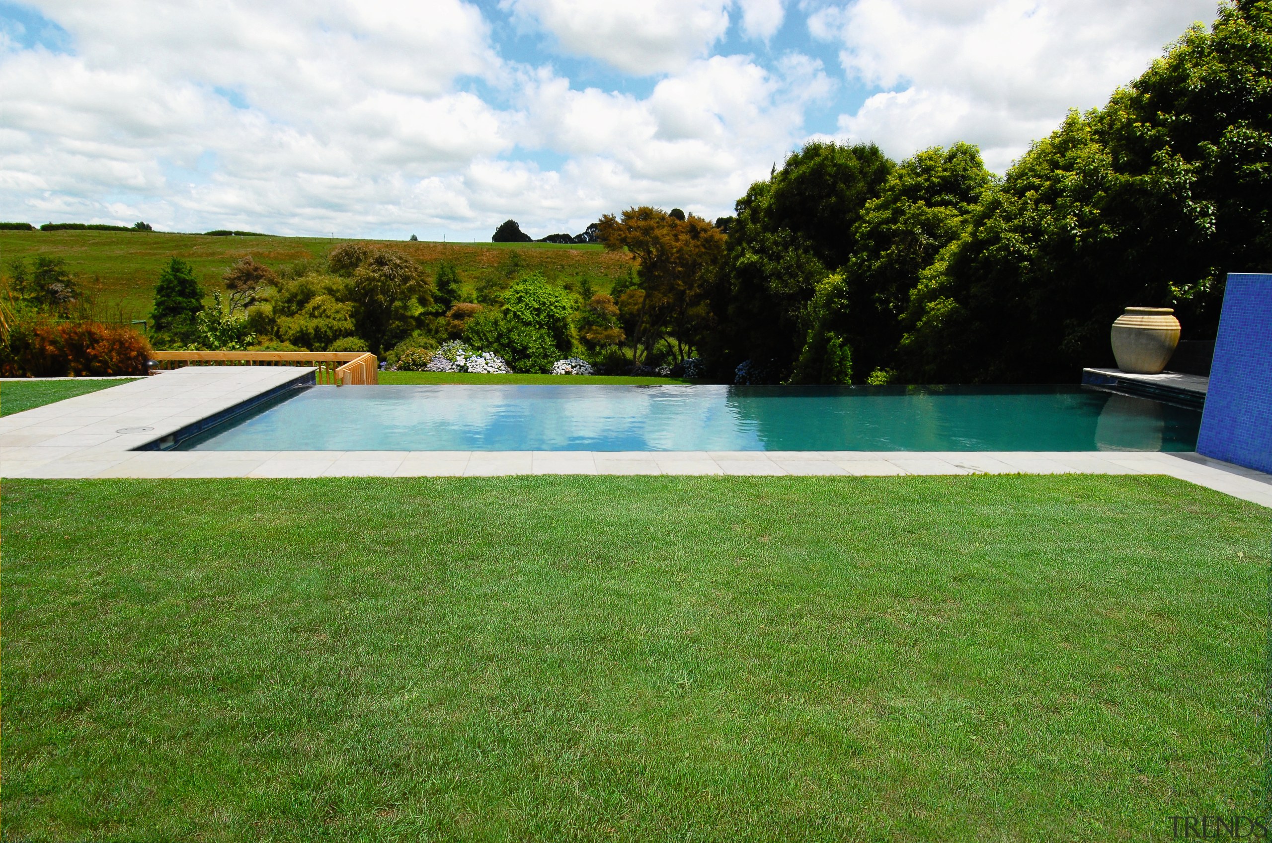 A view of a swimming pool by Pleasure area, backyard, estate, grass, house, lawn, leisure, plant, property, real estate, swimming pool, villa, water, yard, green, white