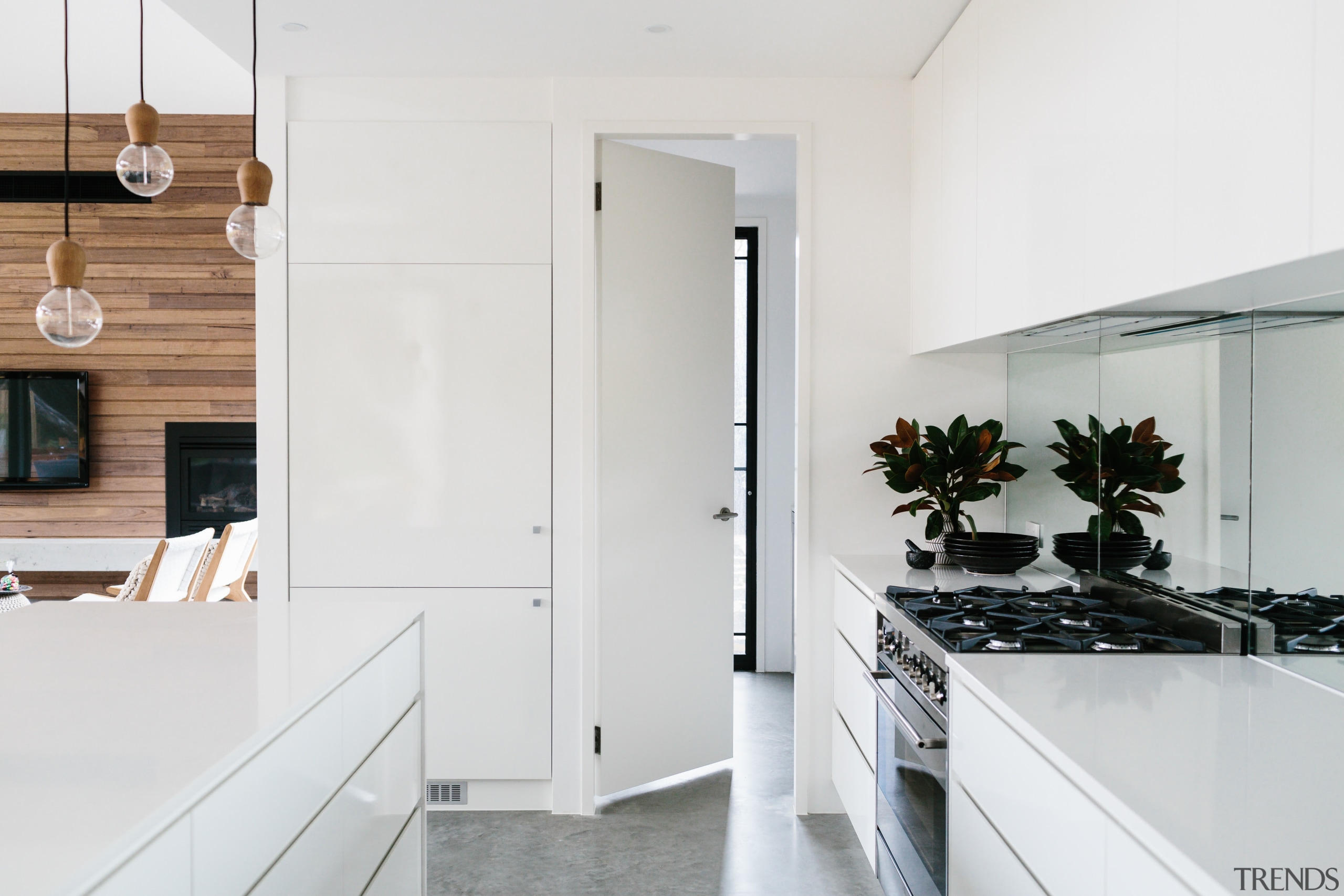 This kitchen combines white surfaces with timber finishes. architecture, countertop, floor, home, house, interior design, kitchen, white