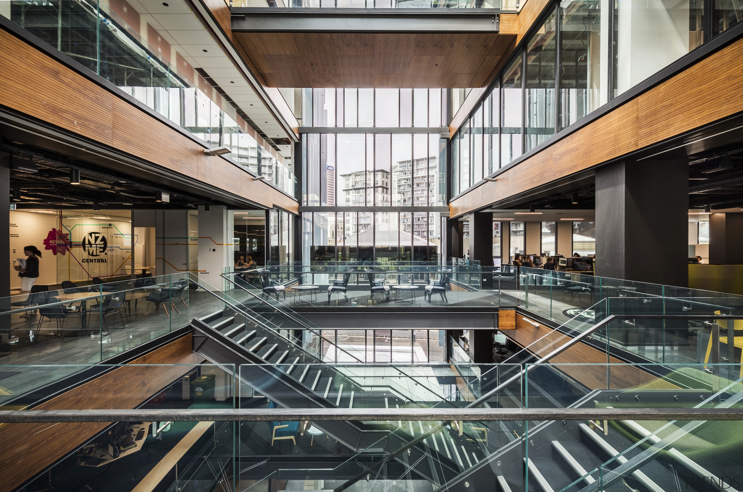 Friendly divide  the glass atrium at the apartment, architecture, building, commercial building, condominium, corporate headquarters, daylighting, headquarters, interior design, leisure centre, lobby, metropolitan area, mixed use, real estate, black