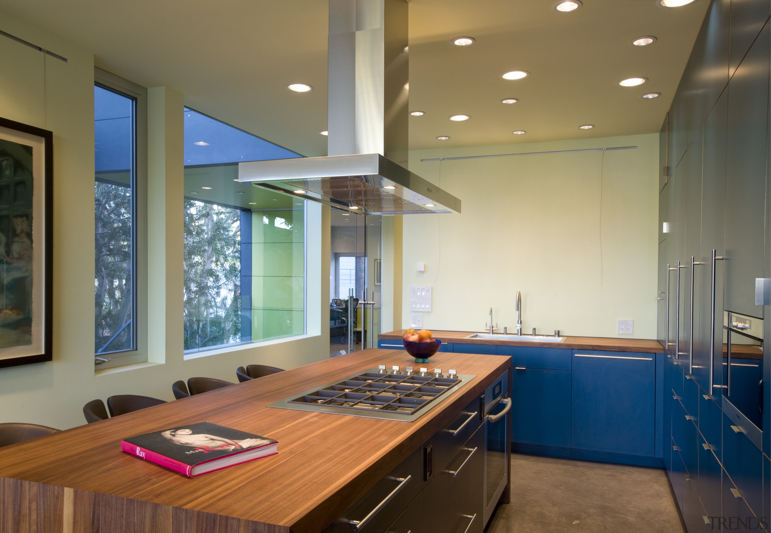 This kitchen features bright cabinetry and a wooden ceiling, countertop, daylighting, interior design, kitchen, real estate, room, window, brown