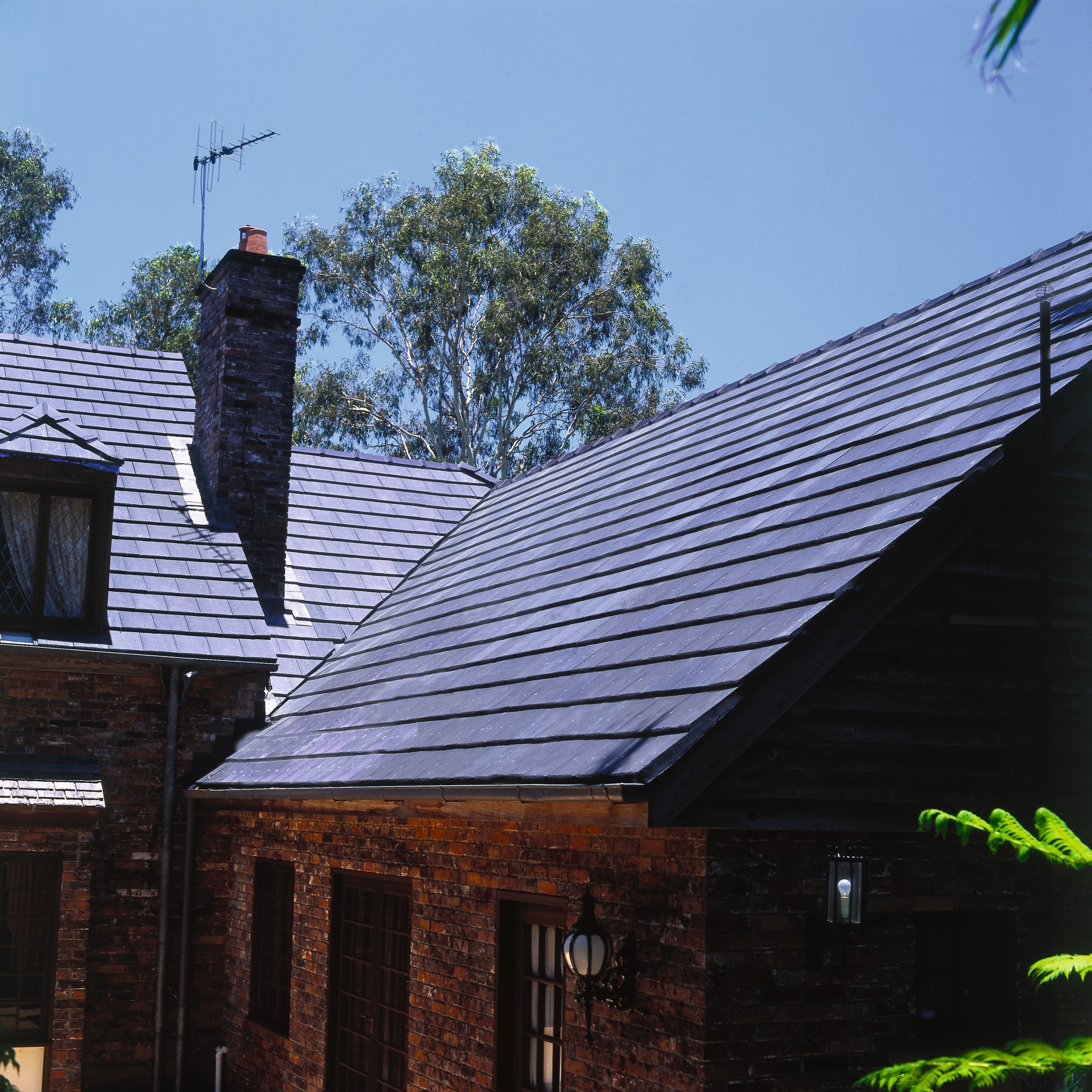 Exterior of house with brick cladding and steep cottage, daylighting, home, house, outdoor structure, real estate, roof, sky, wood, black, teal