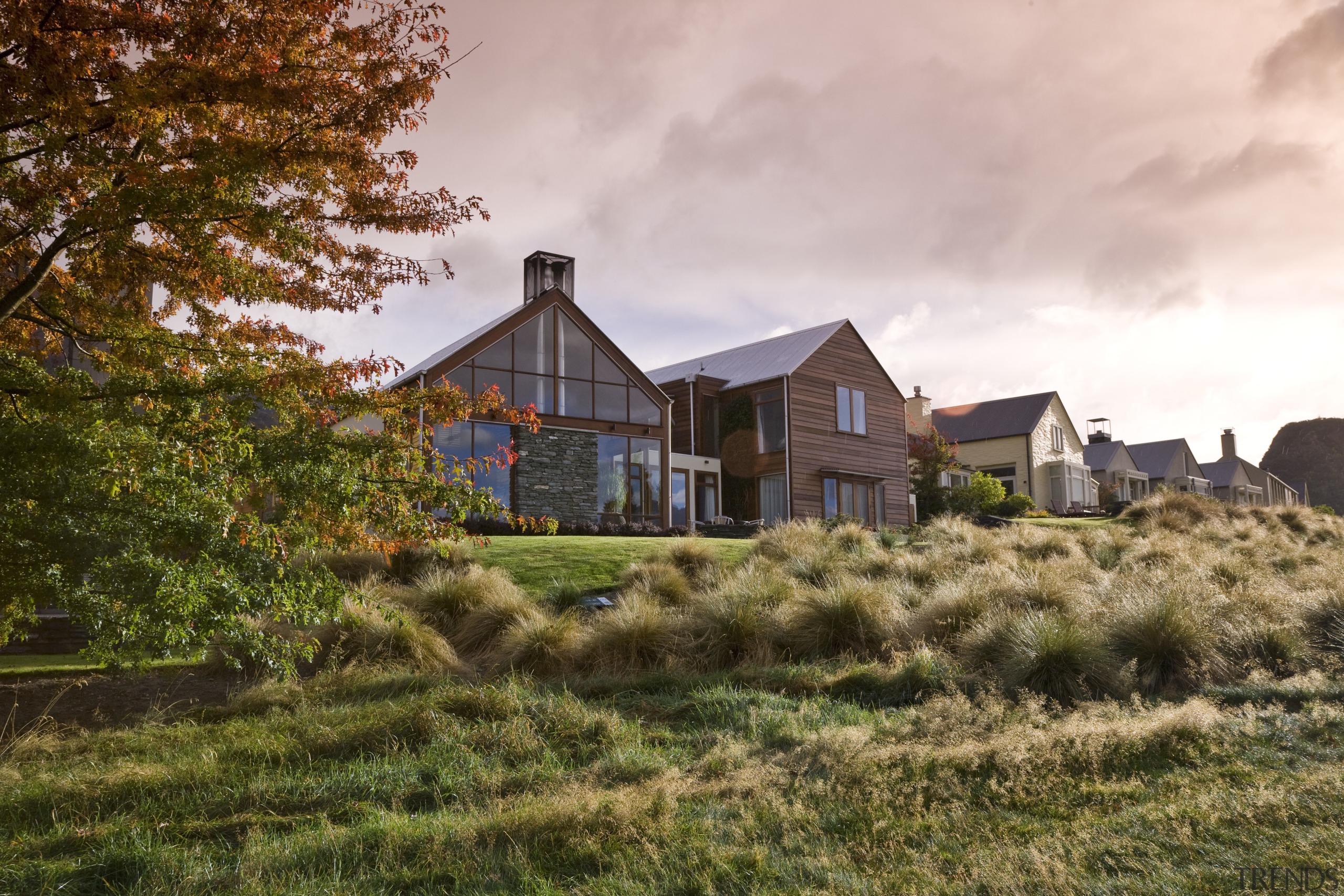 Exterior view of home which is clad with cloud, cottage, estate, farmhouse, grass, home, house, landscape, plant, property, real estate, residential area, rural area, sky, suburb, tree, brown, white