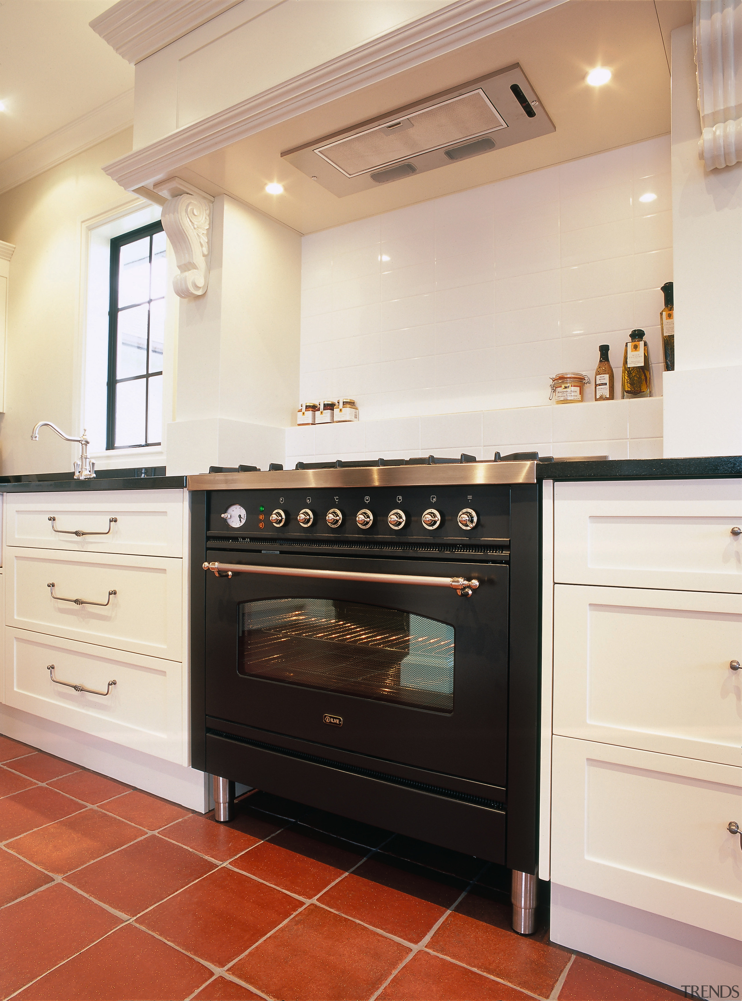 View of black oven set in cream kitchen cabinetry, countertop, cuisine classique, floor, flooring, home appliance, interior design, kitchen, kitchen appliance, kitchen stove, major appliance, oven, room, white