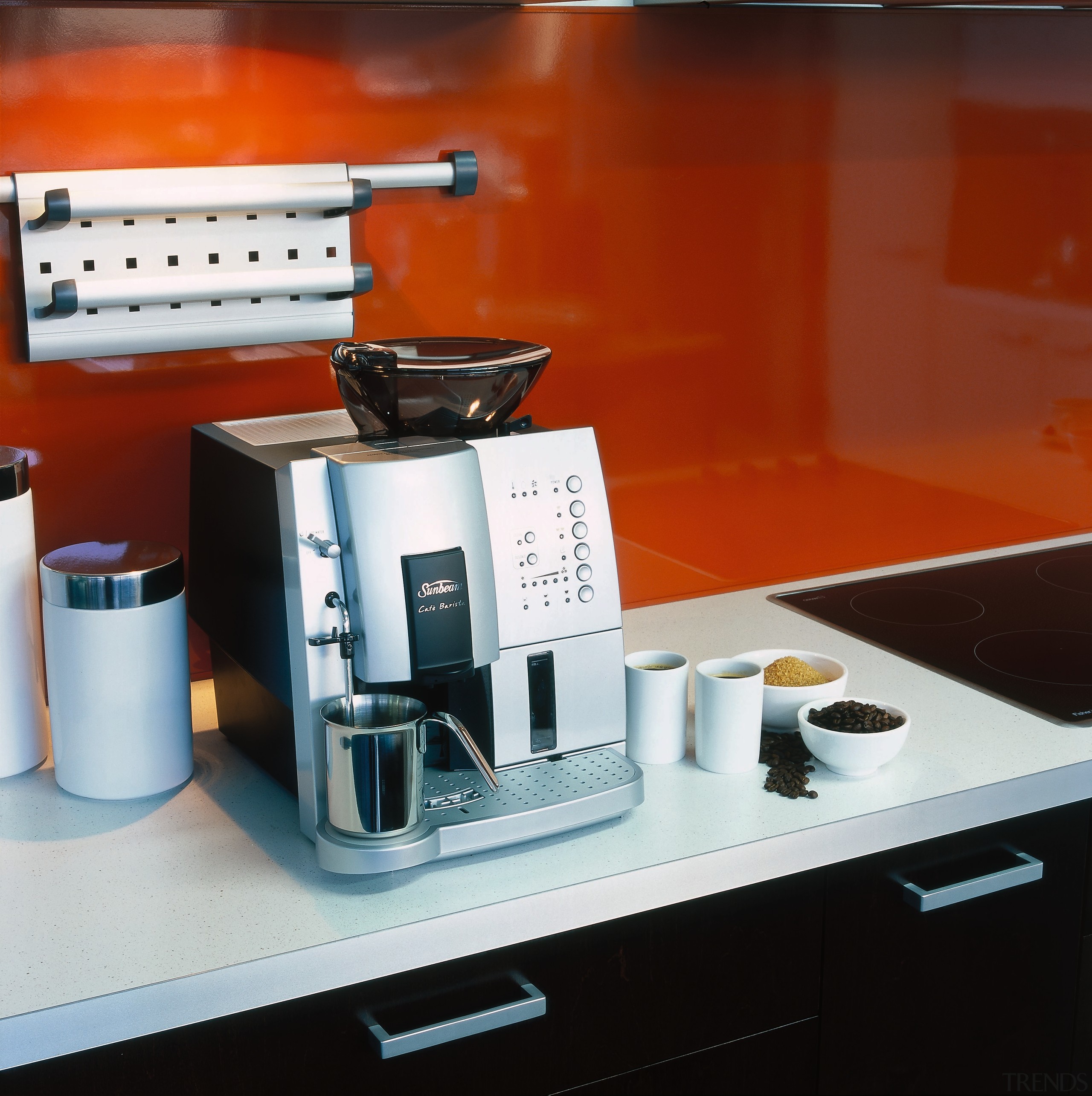 Coffee making machine on white benchtop with black product, product design, small appliance, red, white, black