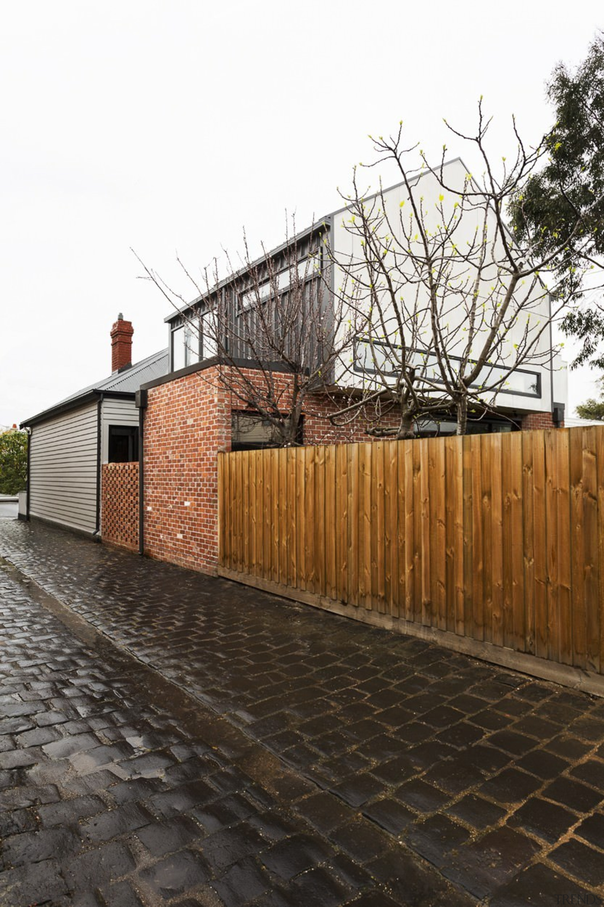 Wood, brick and concrete make for interesting exterior architecture, building, facade, fence, house, iron, outdoor structure, property, residential area, tree, walkway, wall, wood, white, black