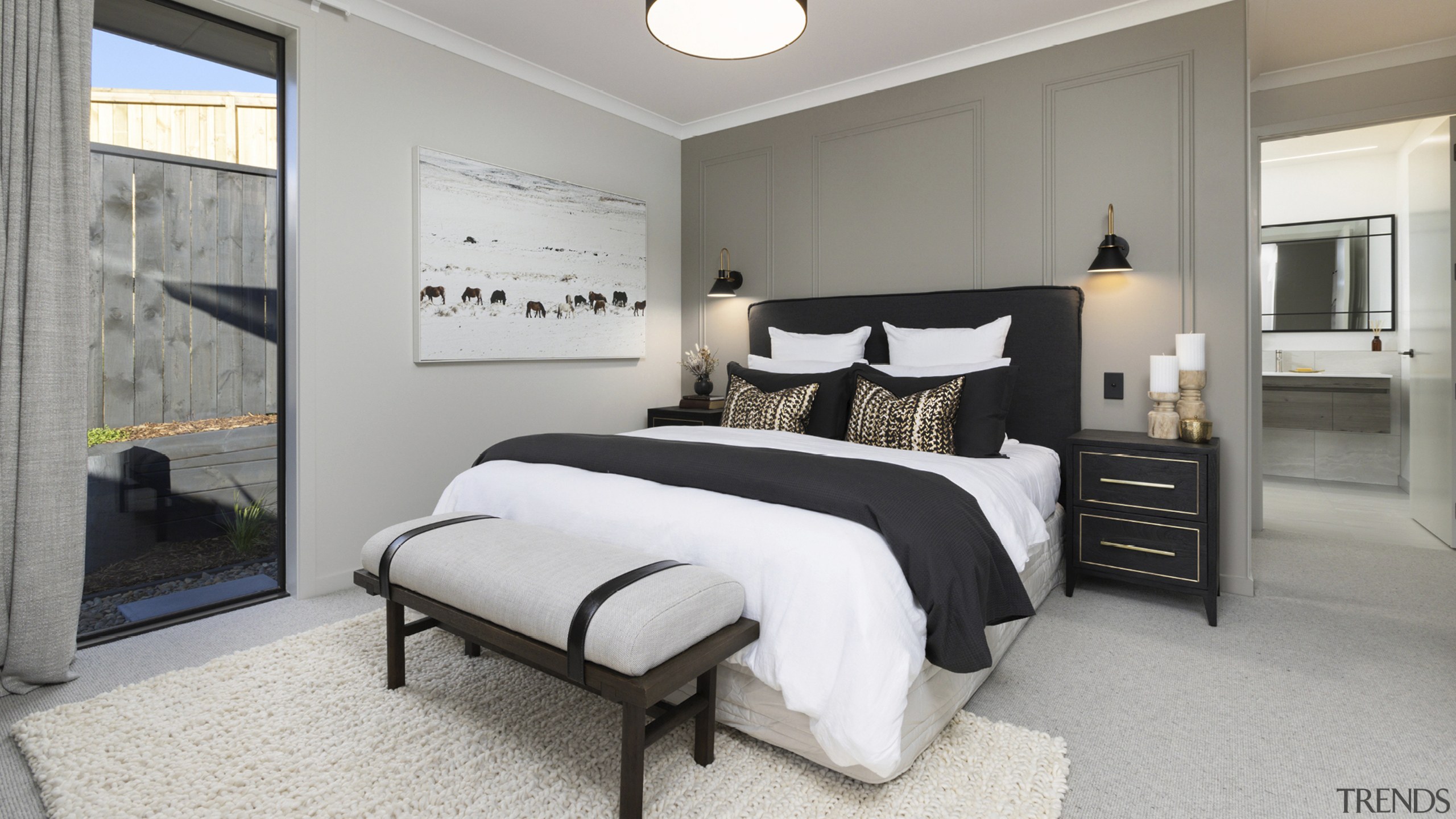 A feature panelled wall backs the bed in 