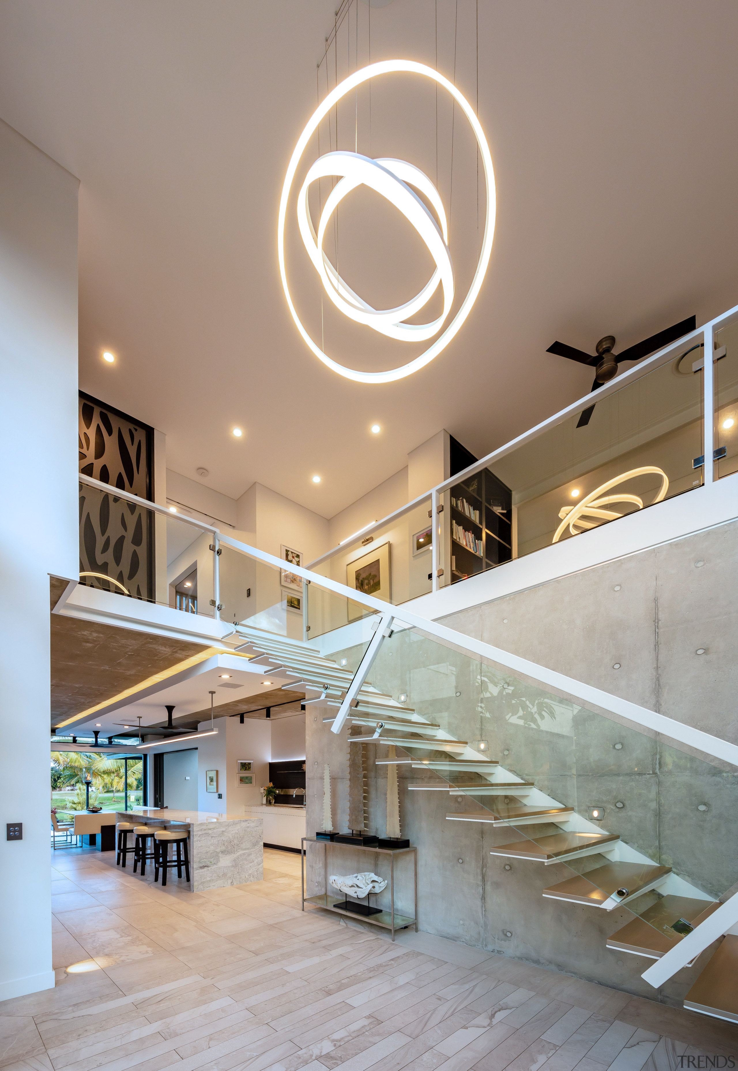 ​​​​​​​A dramatic pendant draws attention to the scale apartment, architecture, ceiling, daylighting, handrail, home, house, interior design, lobby, stairs, gray
