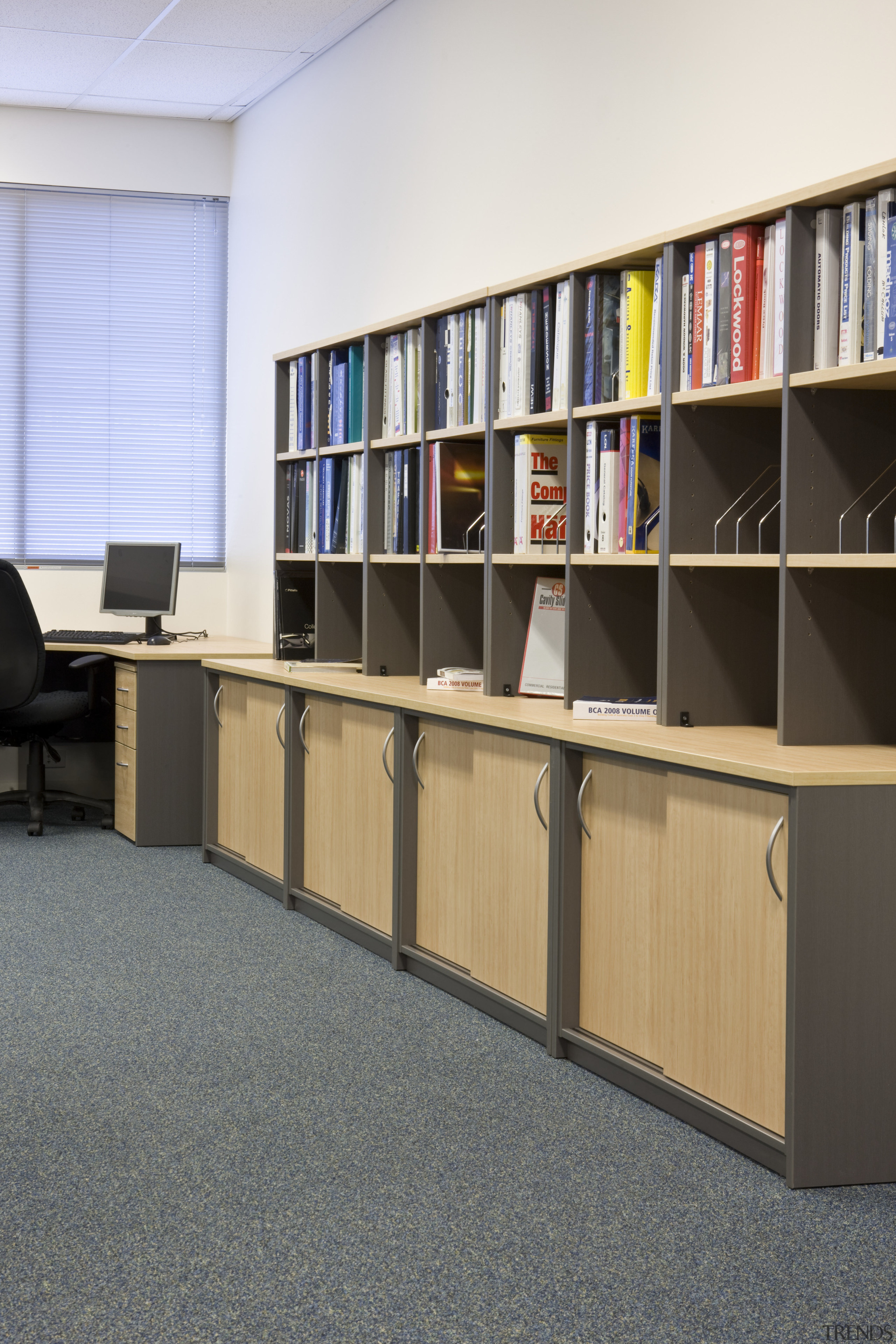 Image of desk and shelving supplied by The bookcase, flooring, furniture, institution, library, library science, public library, shelf, shelving, gray